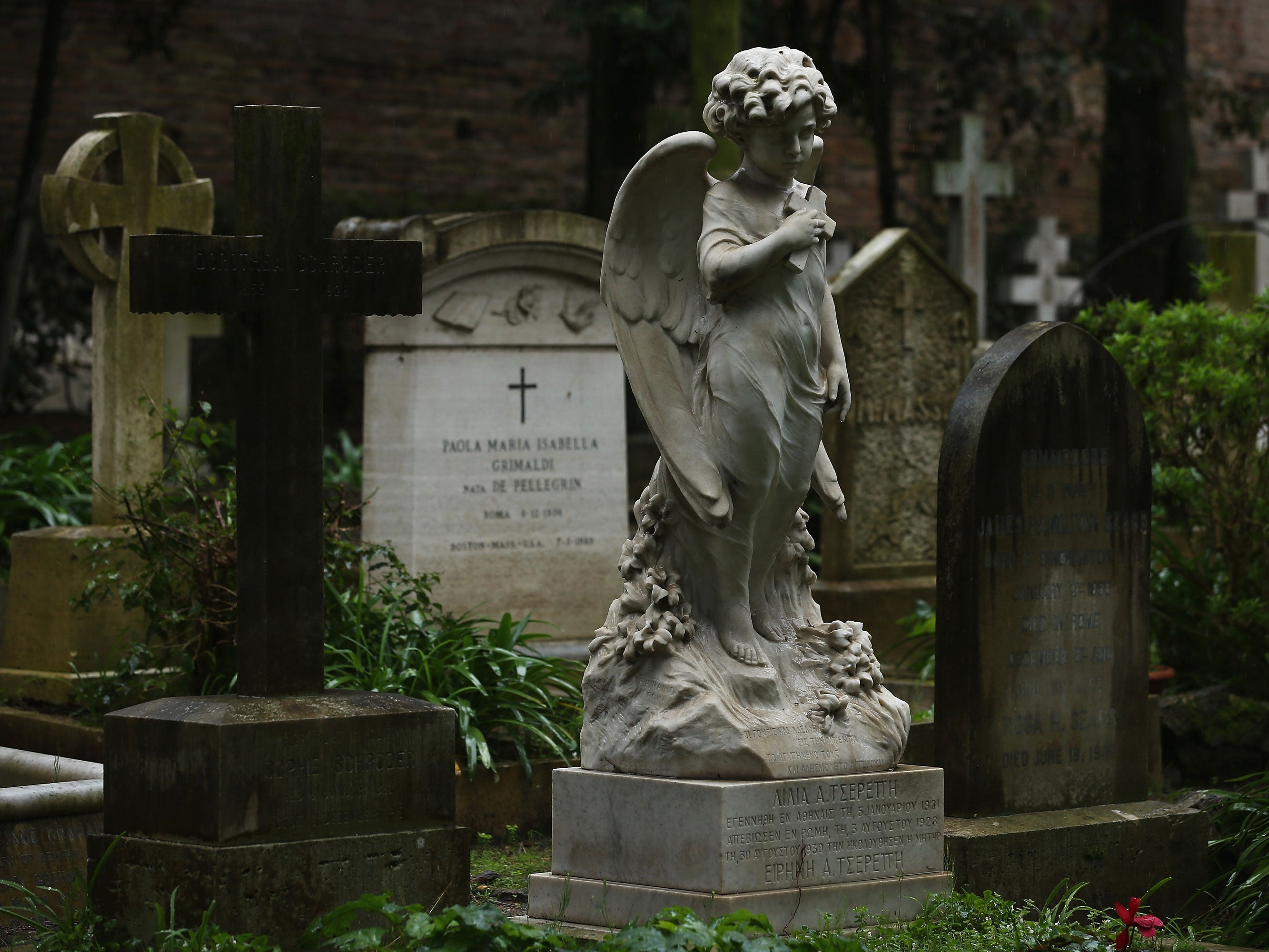 A gravestone stands in a cemetary