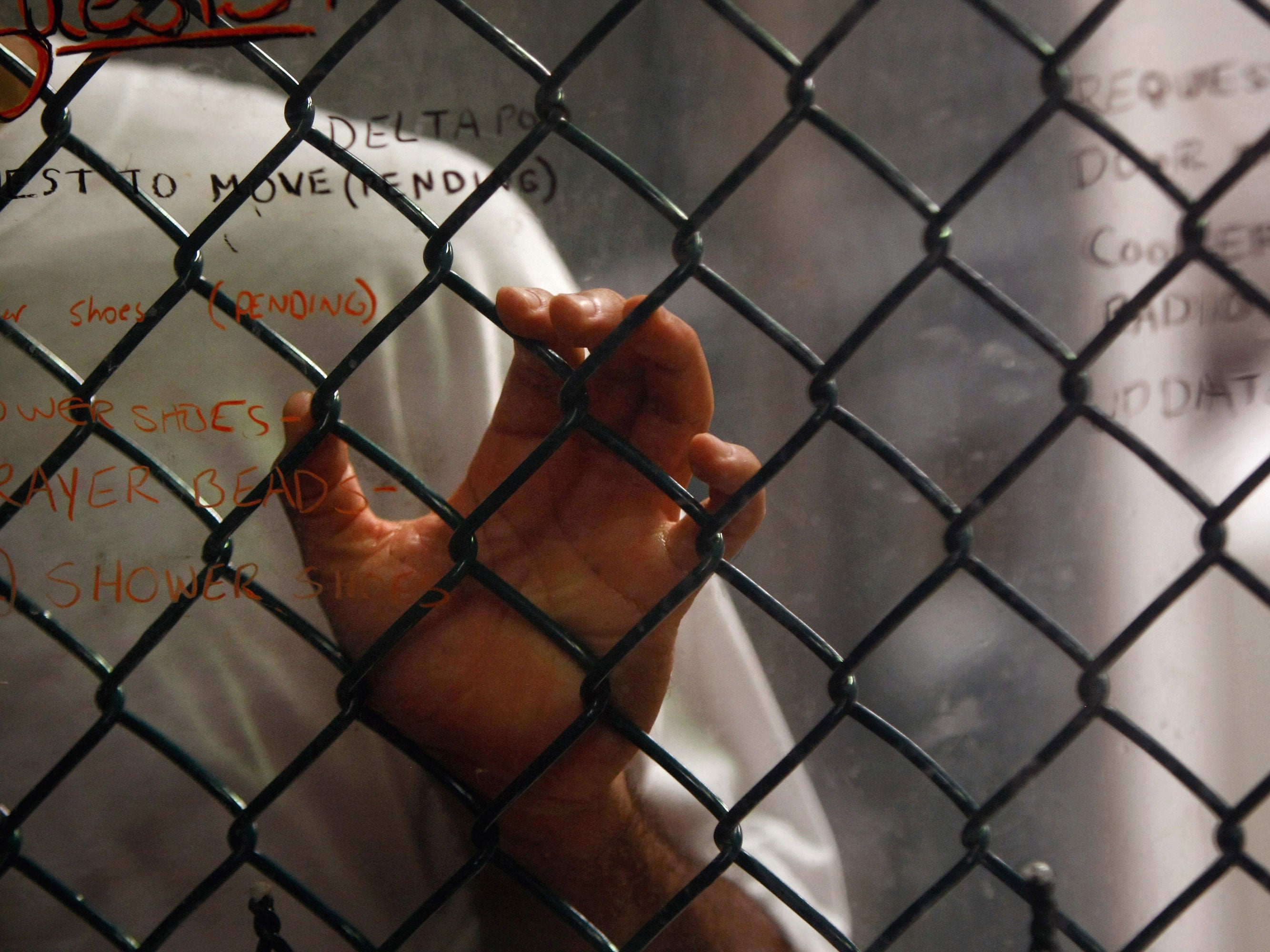 A detainee stands at an interior fence at the U.S. military prison for 'enemy combatants' on October 28, 2009 in Guantanamo Bay, Cuba.