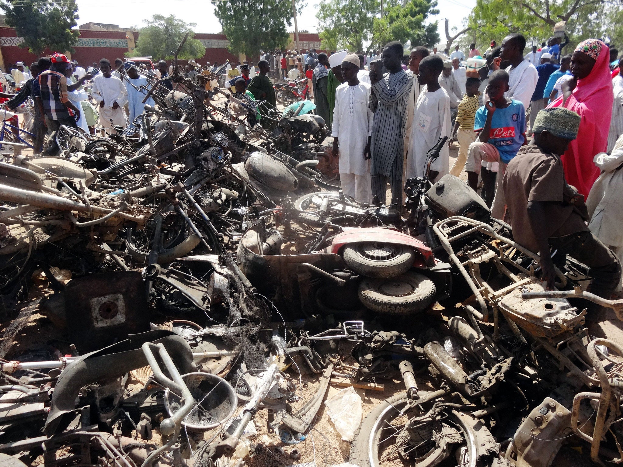 Residents look at a burnt motorcycles outside Kano's central mosque following an attack last month