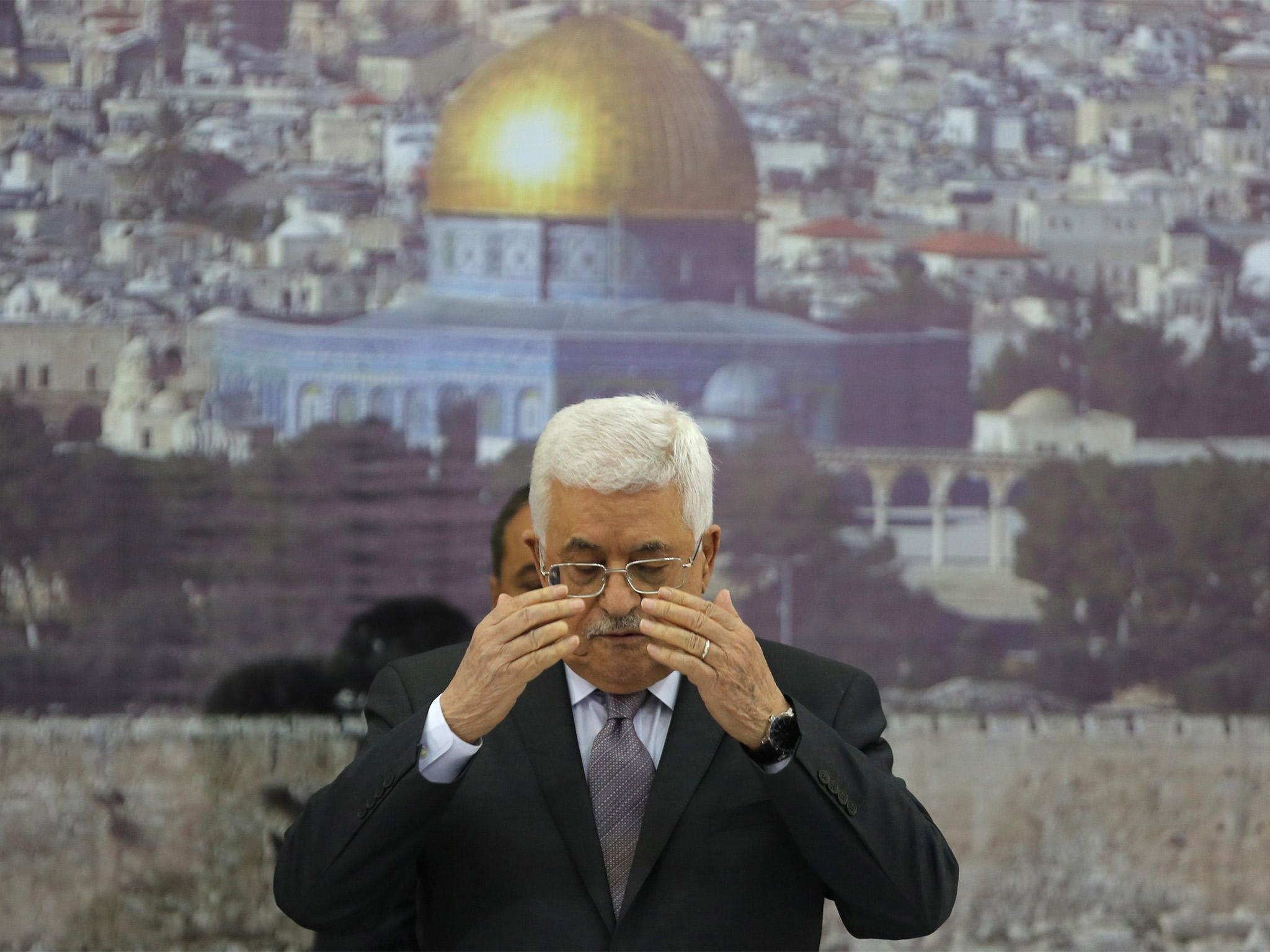 Palestinian President Mahmoud Abbas prays at the start of a leadership meeting following the death of Palestinian minister Ziad Abu Ein