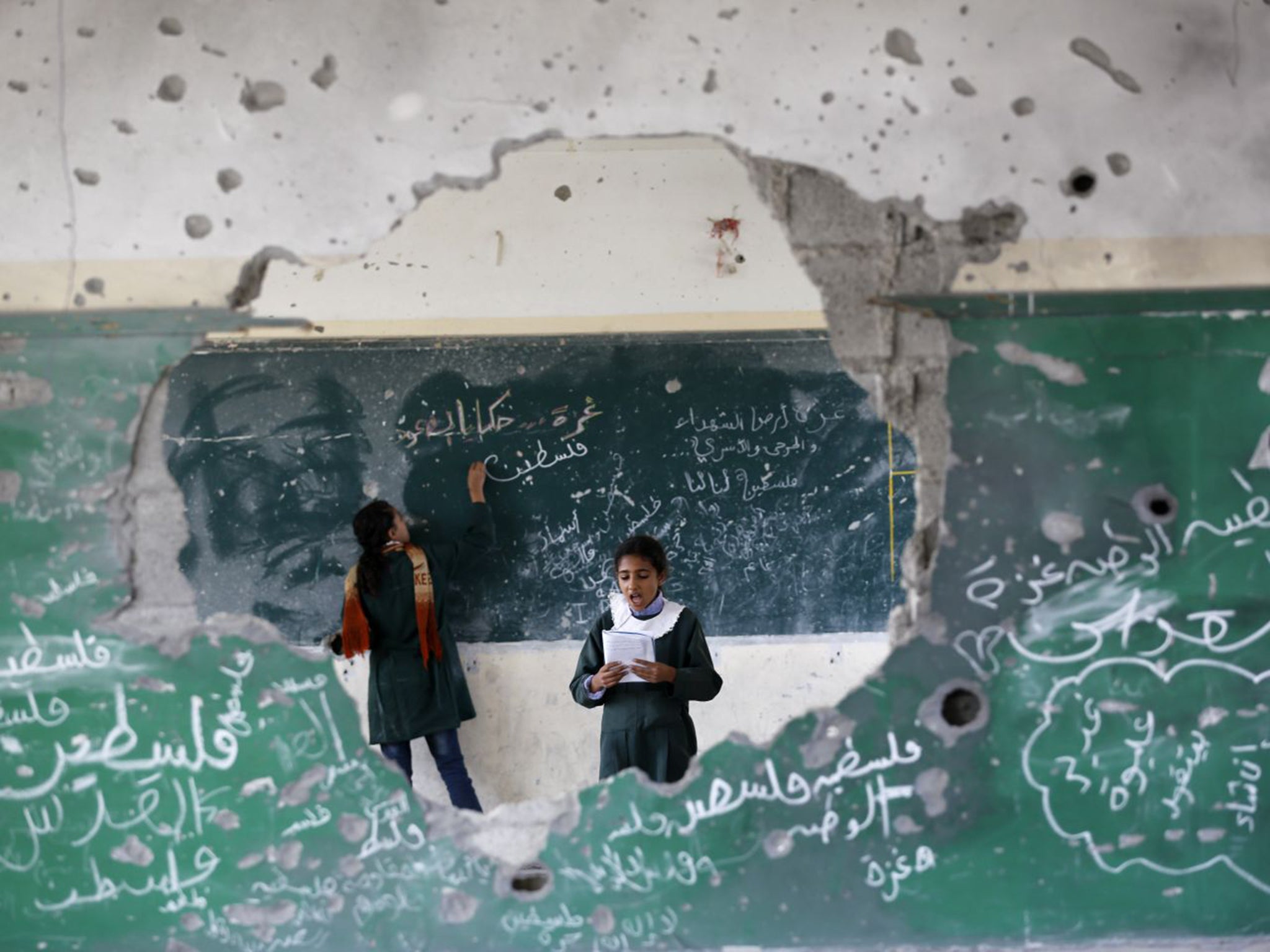 Palestinian girls play inside their school which was destroyed during the 50 days of conflict between Israel and Hamas last summer, in the Shejaiya neighborhood of Gaza City