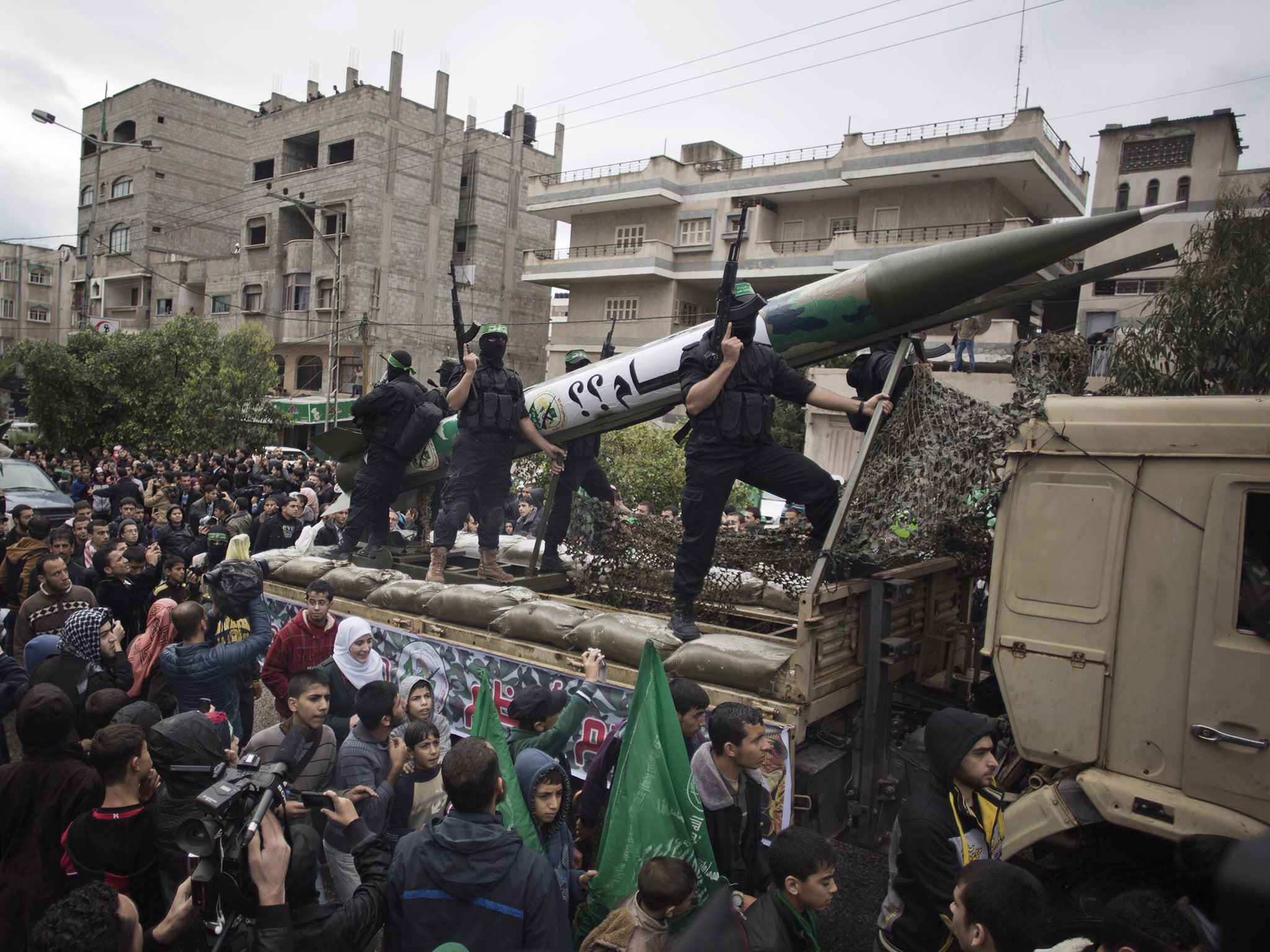 Masked members parade in a rally to commemorate the 27th anniversary of the Hamas militant group