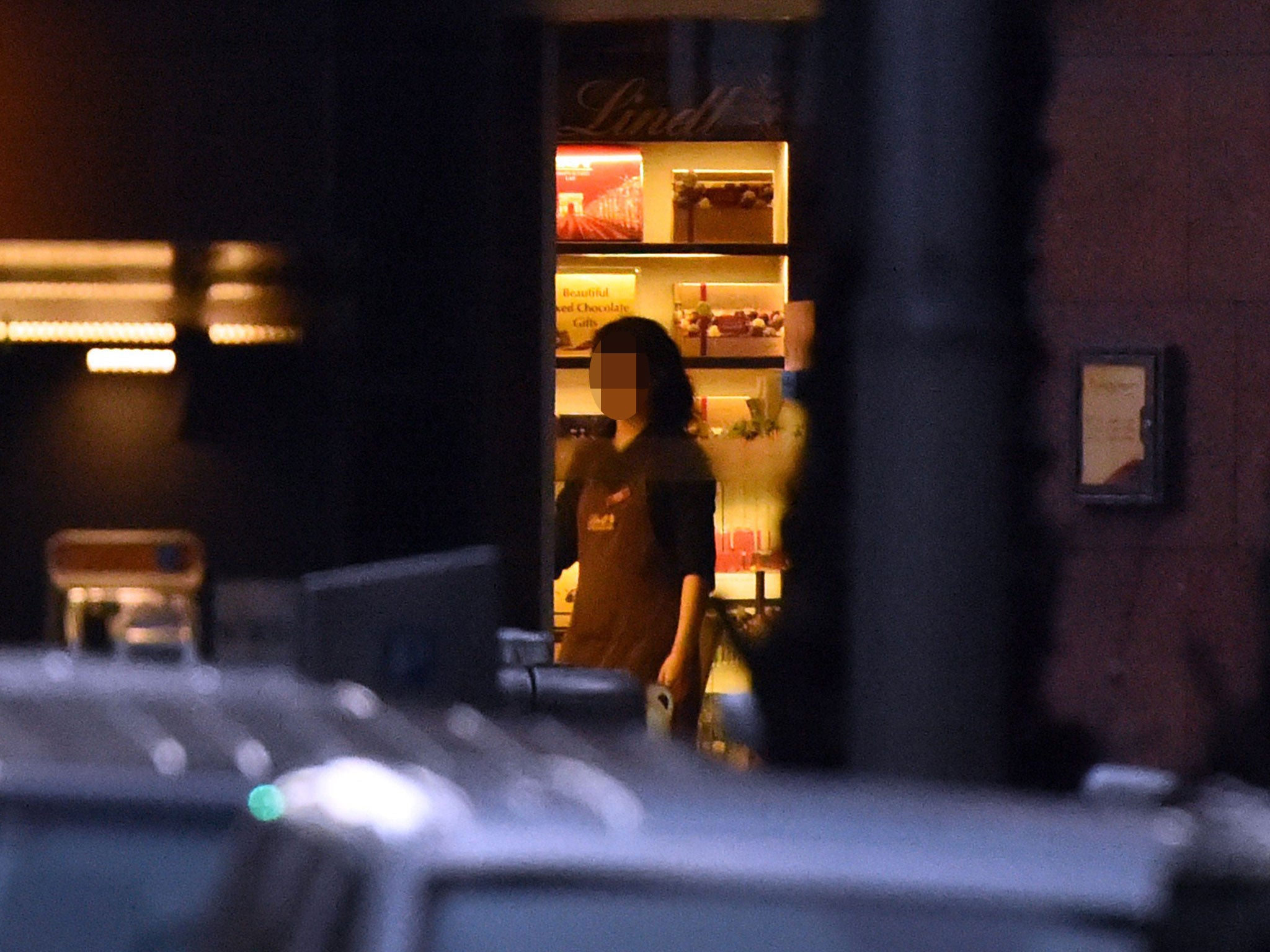 A female hostage stands by the front entrance of the cafe as she turns the lights off