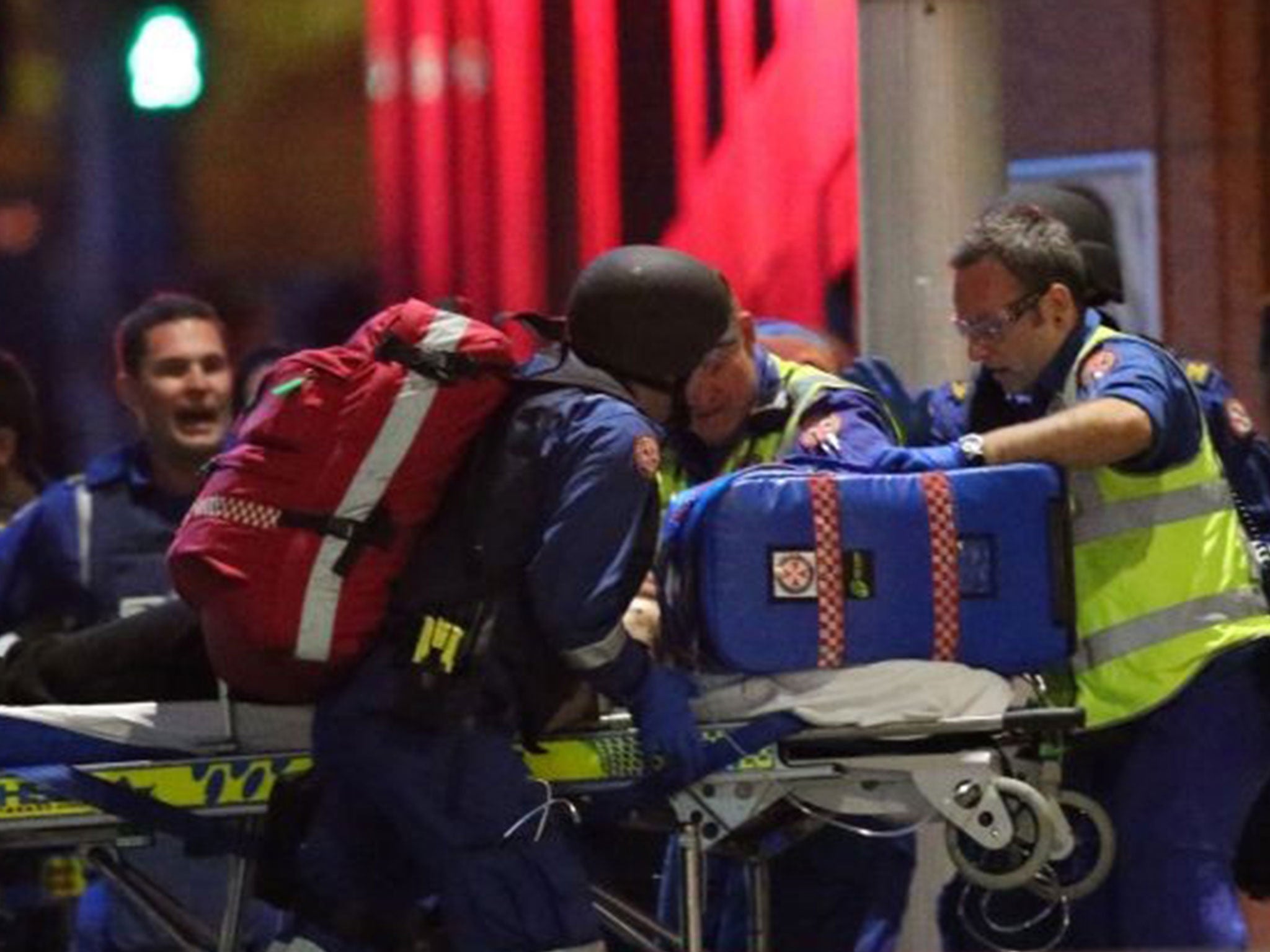 An injured hostage is wheeled to an ambulance after shots were fired during the cafe siege in Sydney