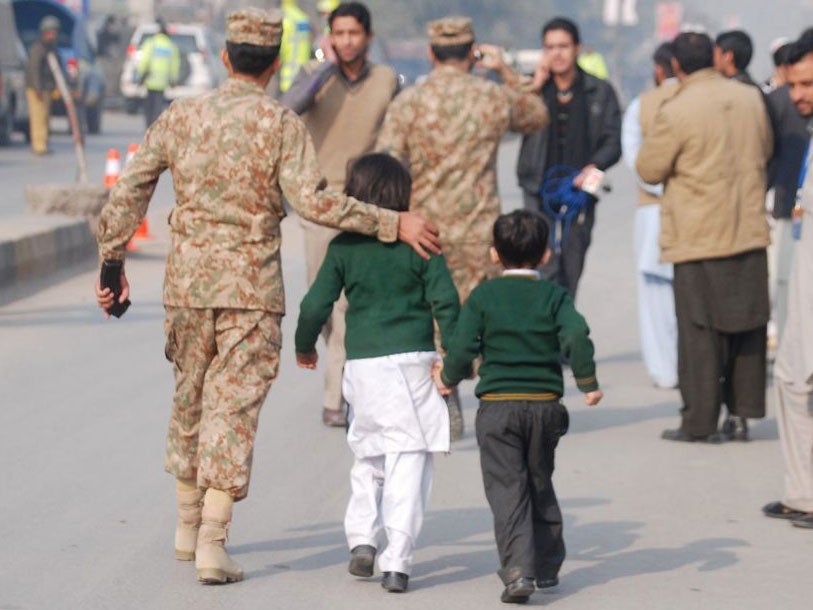 A soldier escorts schoolchildren after they were rescued from the Army Public School