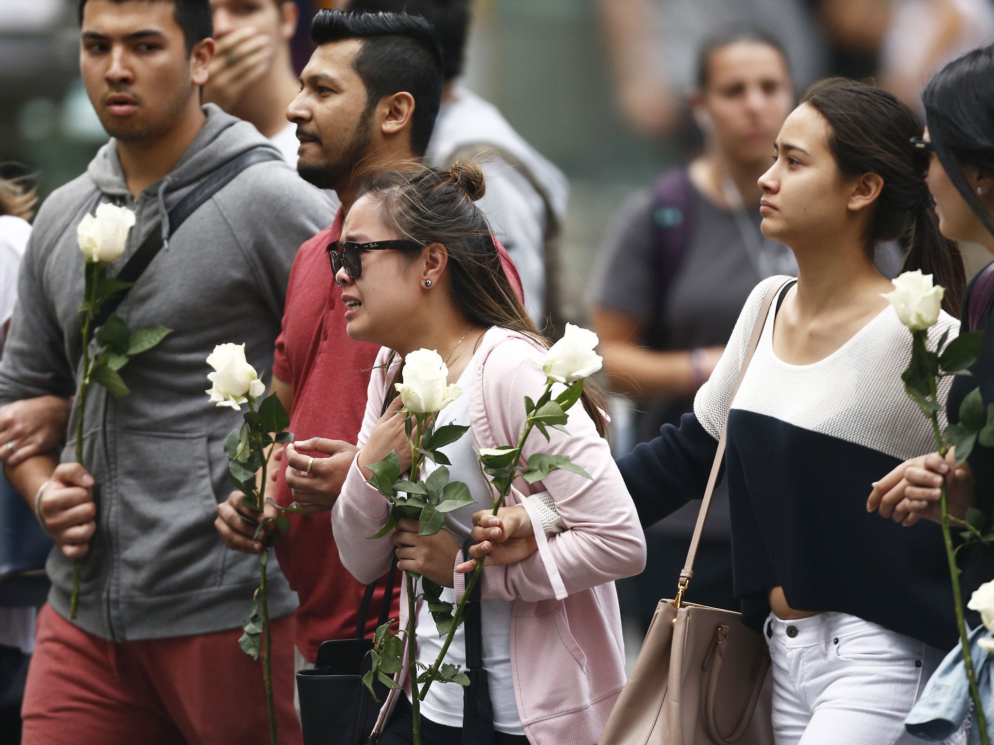 Grieving Lindt cafe workers lay flowers at the scene of the Martin Place siege