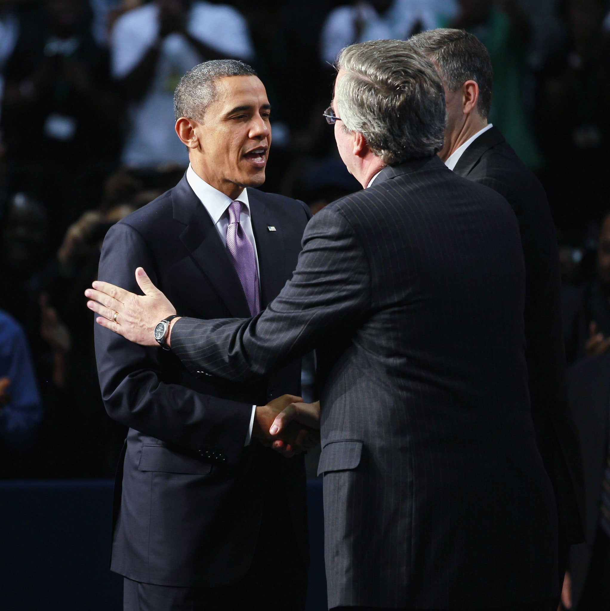 Barack Obama shakes hands with Jeb Bush as he visits Miami Central Senior High School in 2011