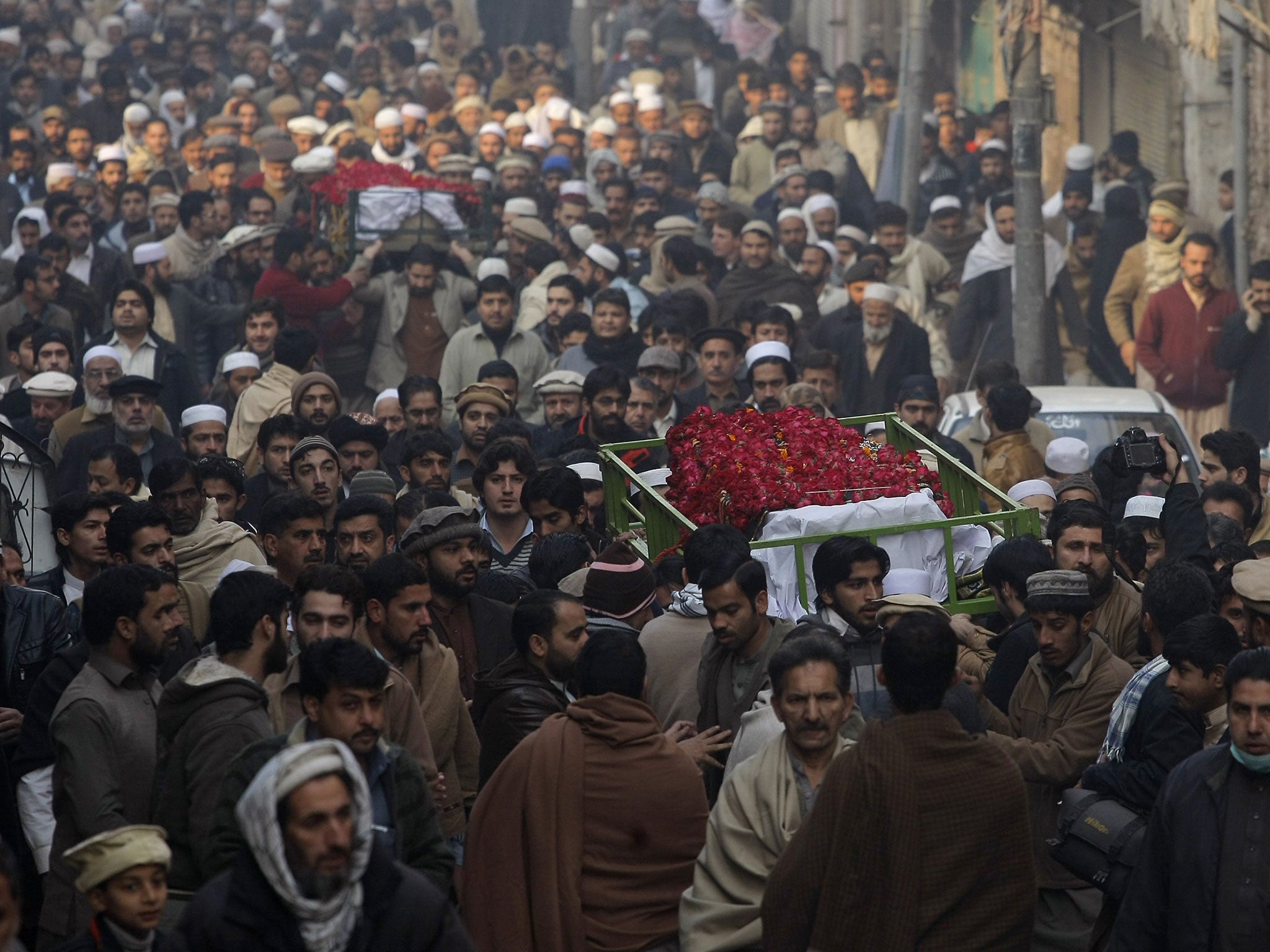 People attend the funeral of a student killed in Tuesday's Taliban attack on a school in Peshawar, Pakistan, on Wednesday, December 17