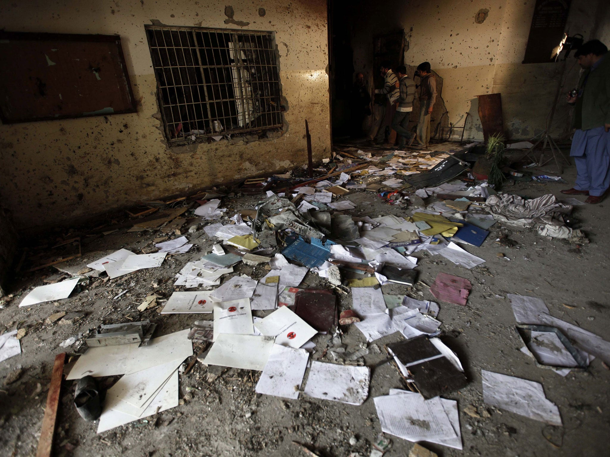 Pakistani security officials inspect the premises in the wake of the attack