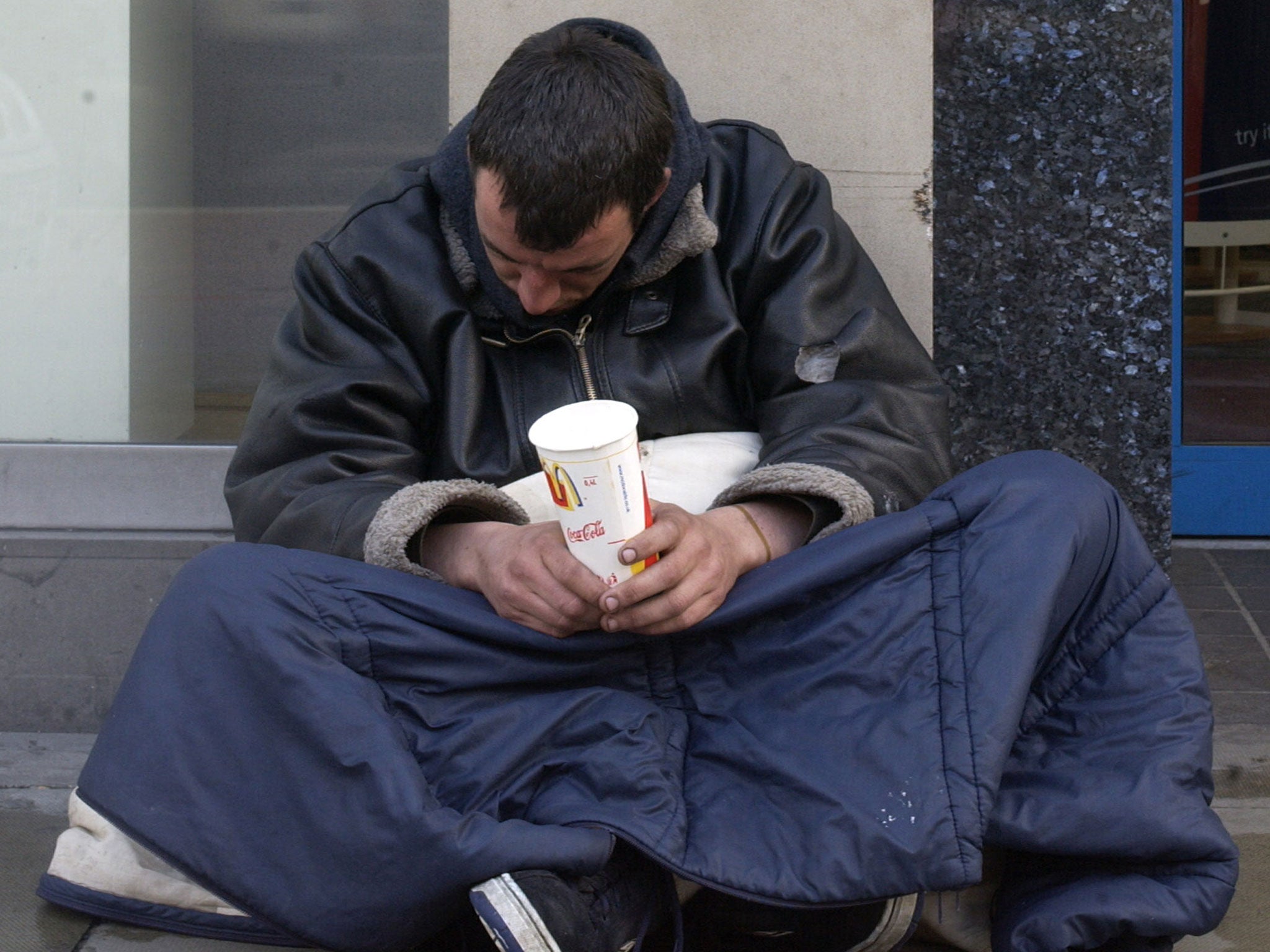 A homeless man begs for change in London.