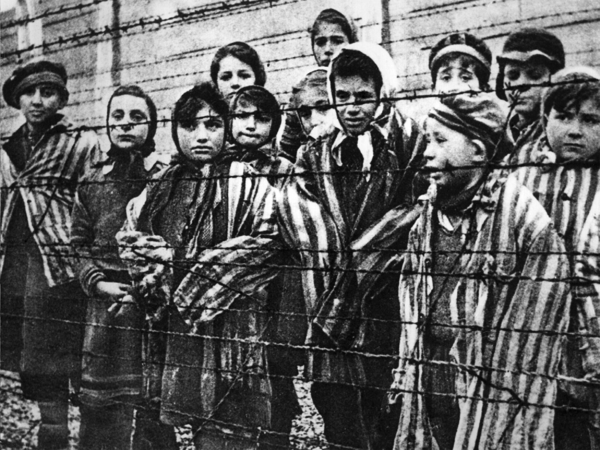 Children behind a barbed wire fence at the Auschwitz Nazi concentration camp (Getty)