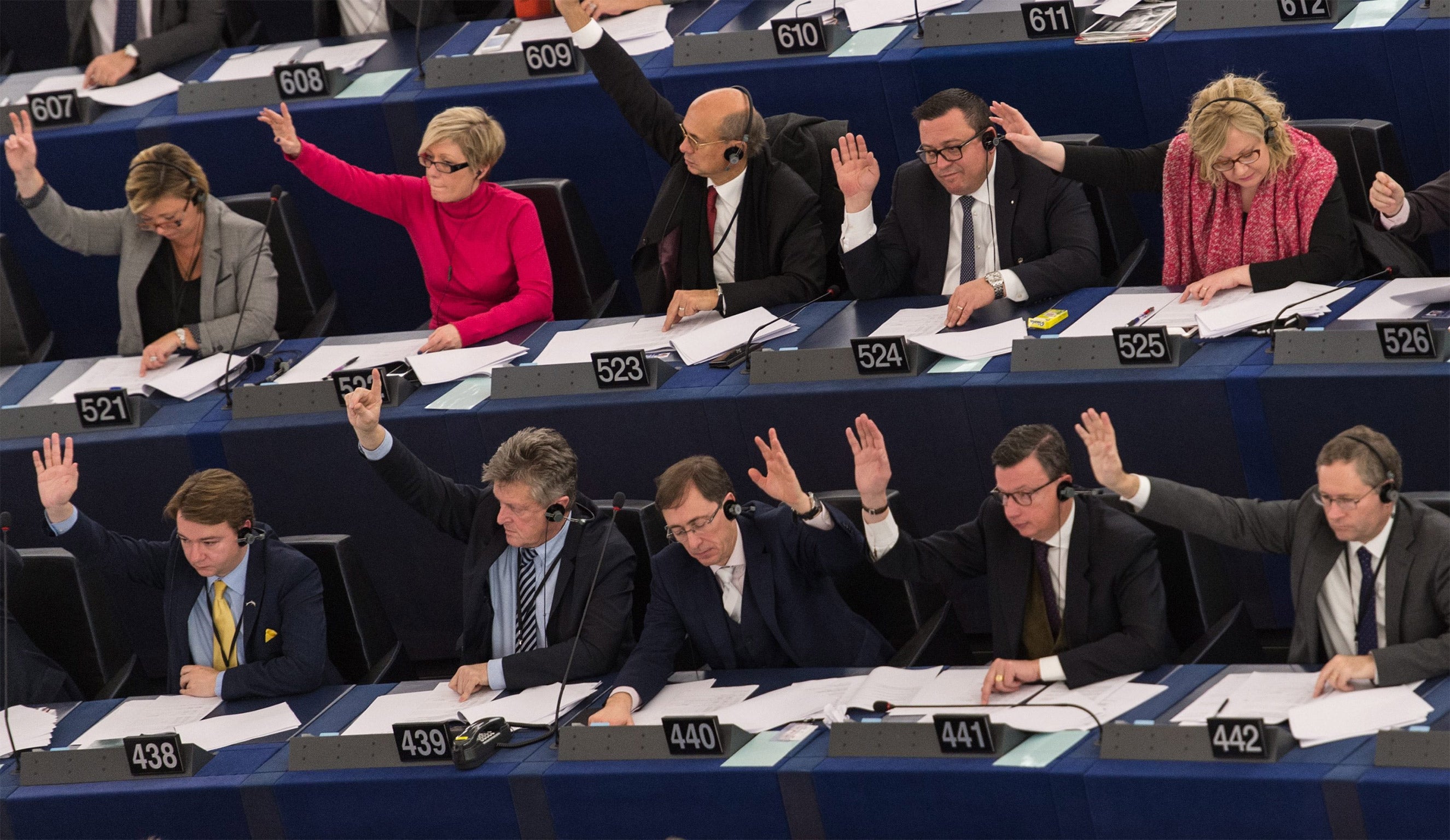 MEPs raise their hands during a vote about recognition of Palestine statehood