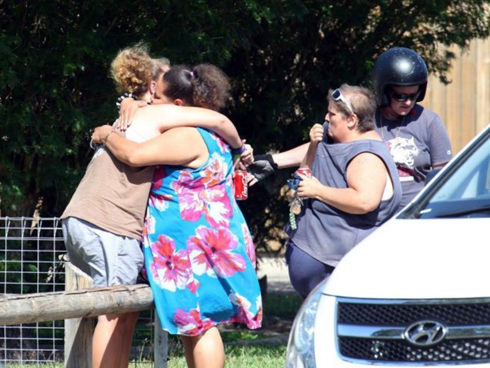 Distraught locals embrace at the scene after eight children were found stabbed to death