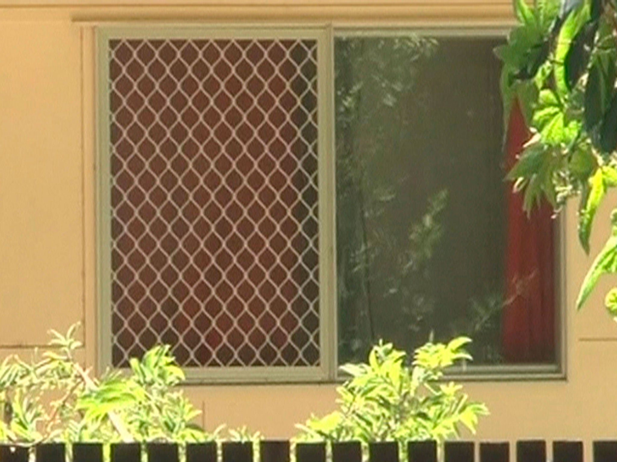 A view of a window of the house where a mass stabbing took place, in the suburb of Manoora in Cairns