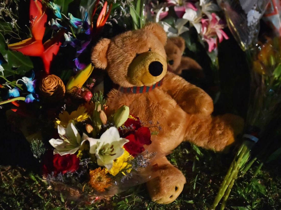 Flowers and stuffed toys are laid opposite the scene where eight children ranging from babies to teenagers were found dead in a house in the northern Australian city of Cairns