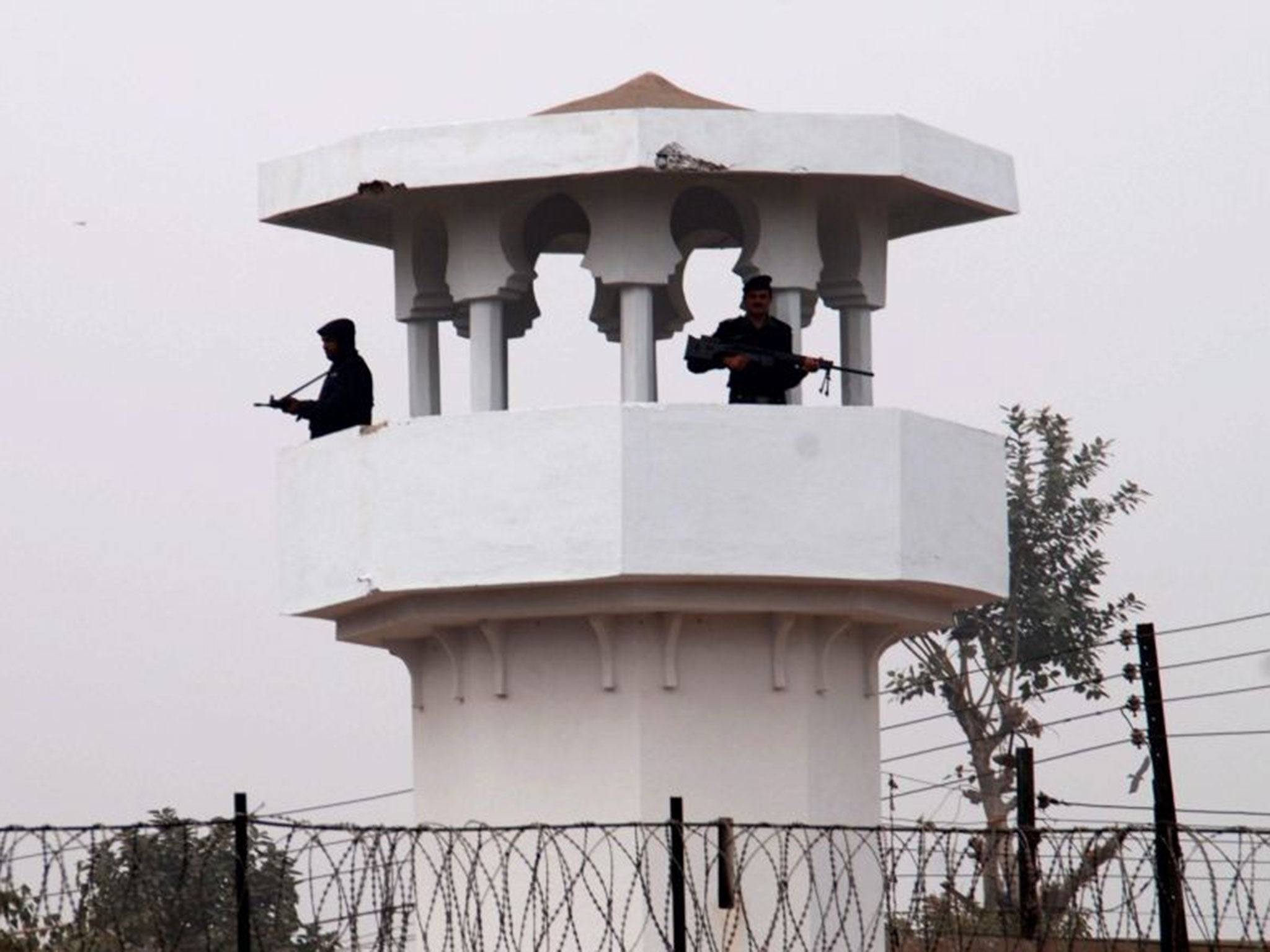 Pakistani police stand guard in the watch tower of Faisalabad central jail