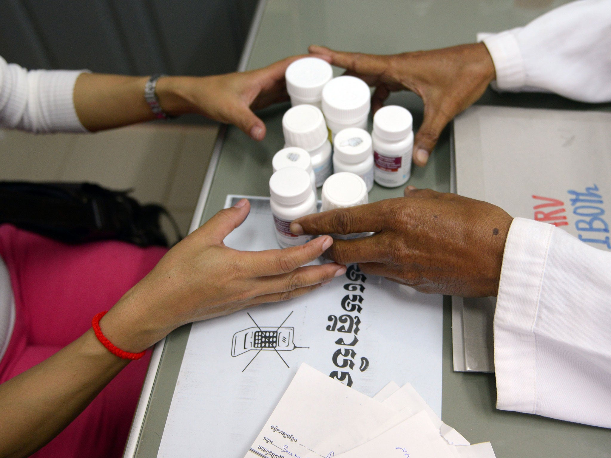 A Cambodian doctor (R) offers Anti Retro Viral (ARV) drugs to a woman (L) who is living with HIV. At least 90 villagers in Cambodia have been diagnosed with HIV