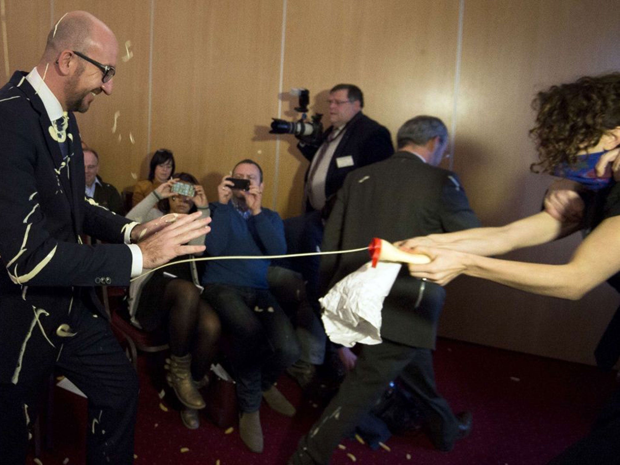 Belgian Prime Minister Charles Michel (L) reacts as activists throw fries and mayonnaise on him during an anti-government protest