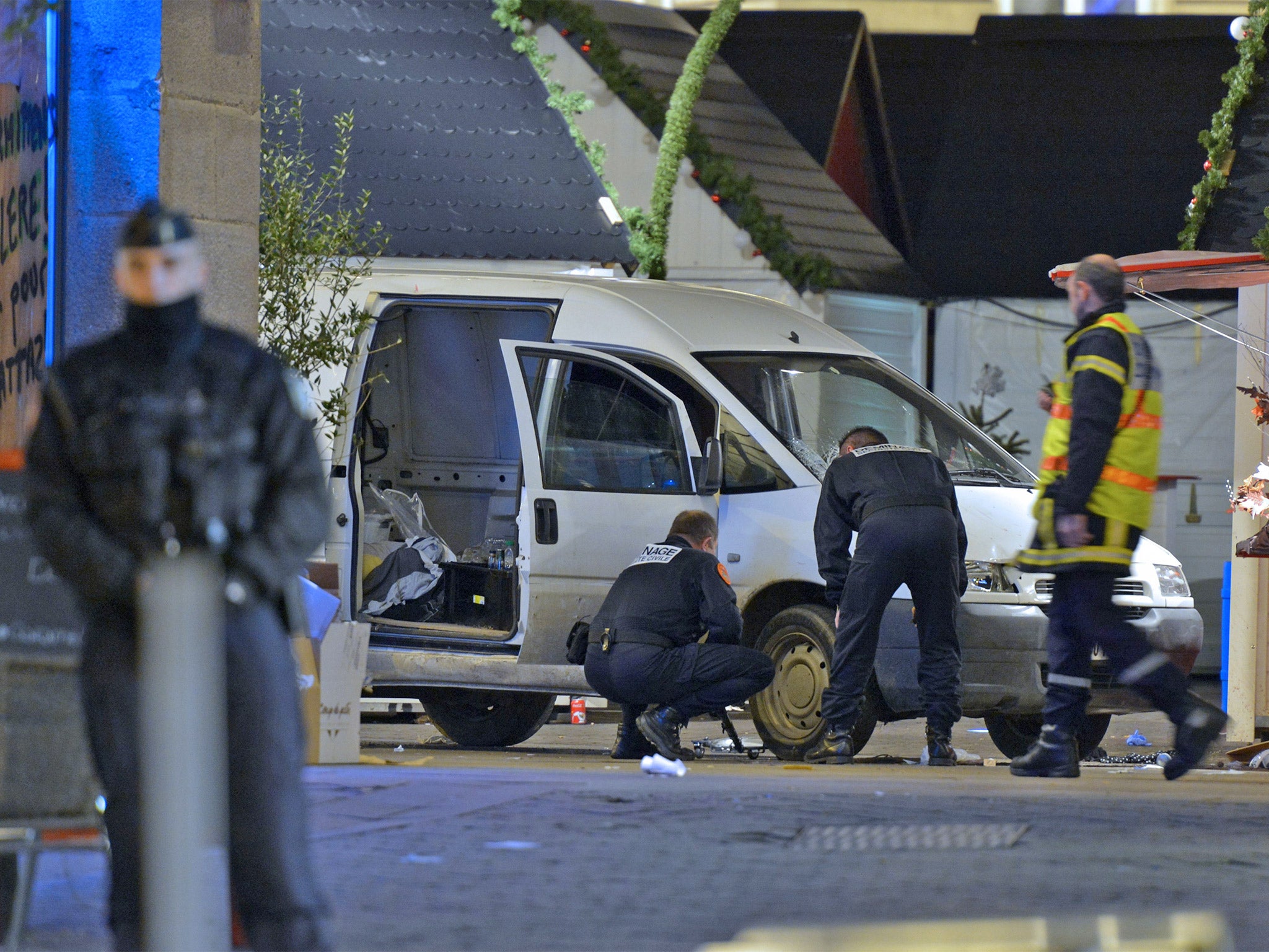 A bomb disposal unit inpects the van a driver used to plough into a Christmas market in Nantes (AFP)