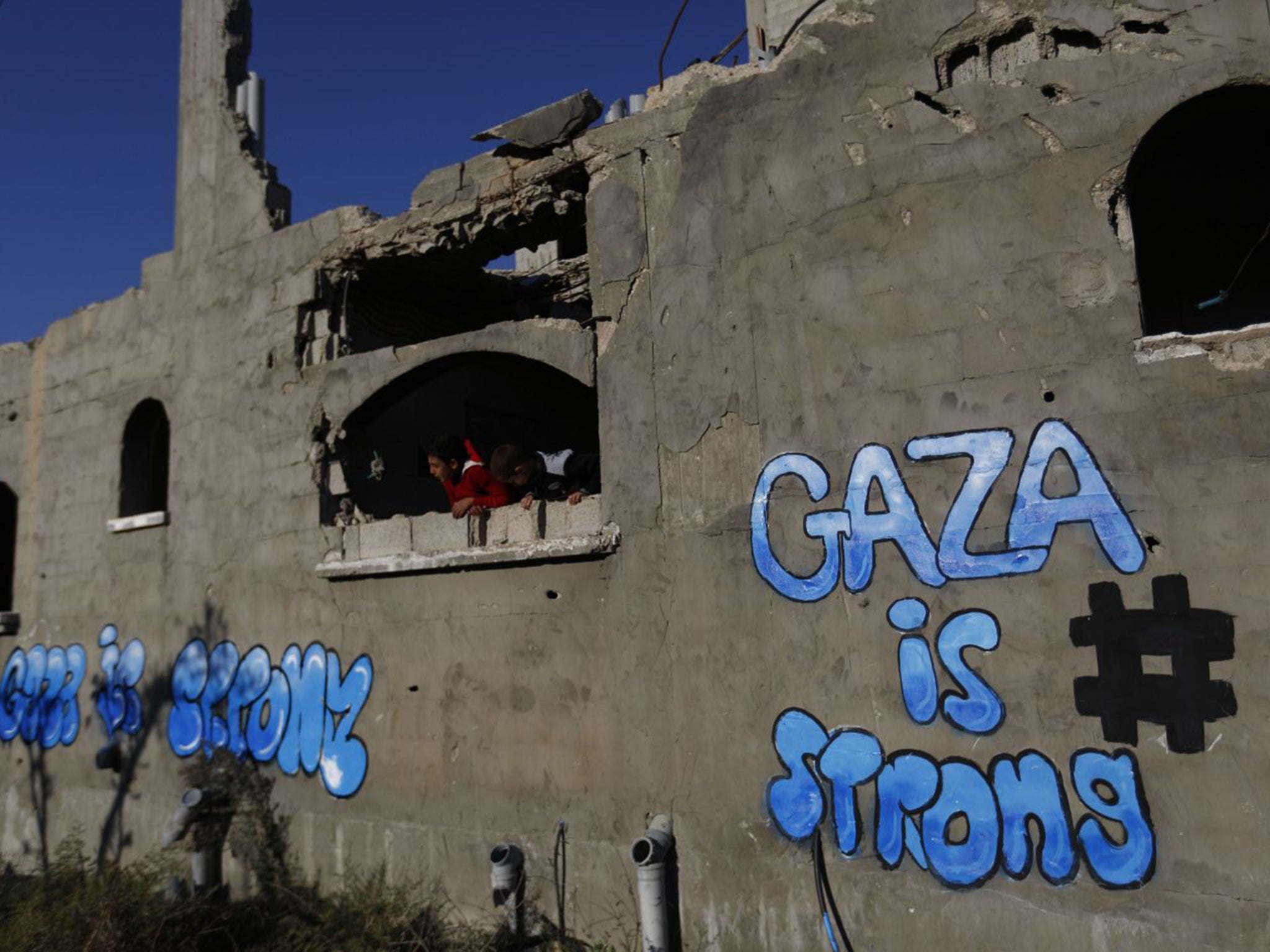 Palestinian children look out of the window of a destroyed building in Gaza City's Al-Shejaiya suburb on December 25th