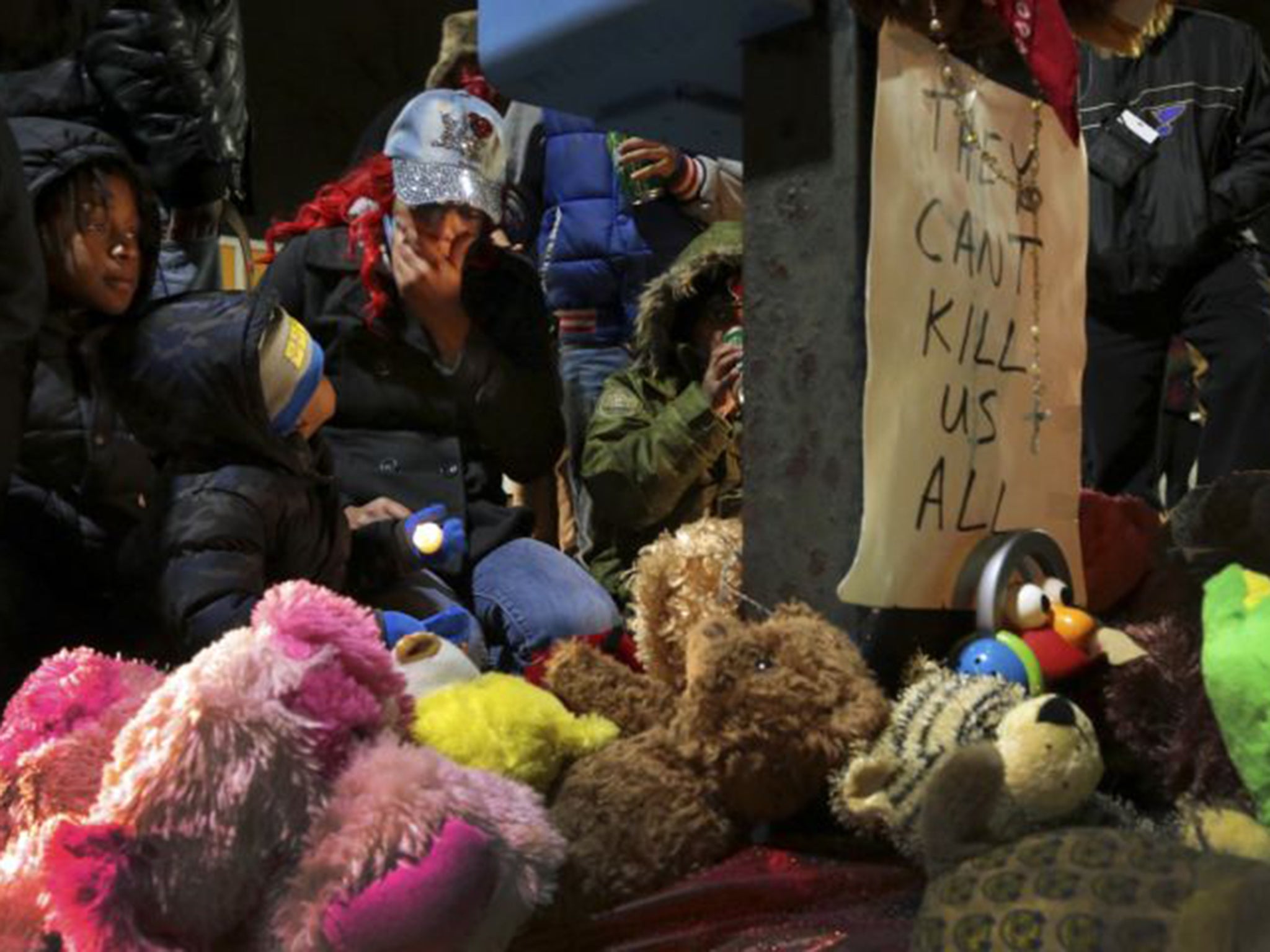 Courtney Palmer, centre, a cousin of Antonio Martin, mourns the loss at a growing memorial in a gas station parking lot in Berkeley