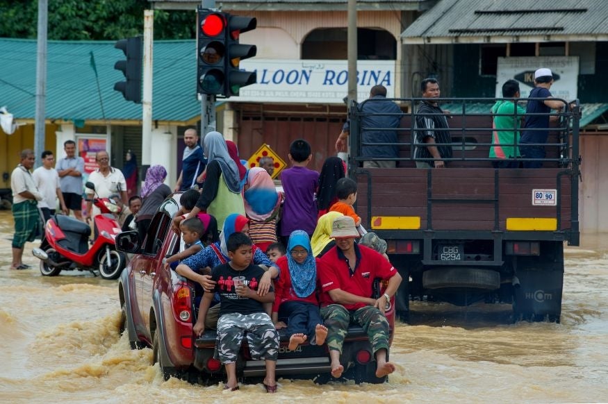 Local residents use trucks to cross flooded streets in Pengkalan Chepa, near Kota Bharu