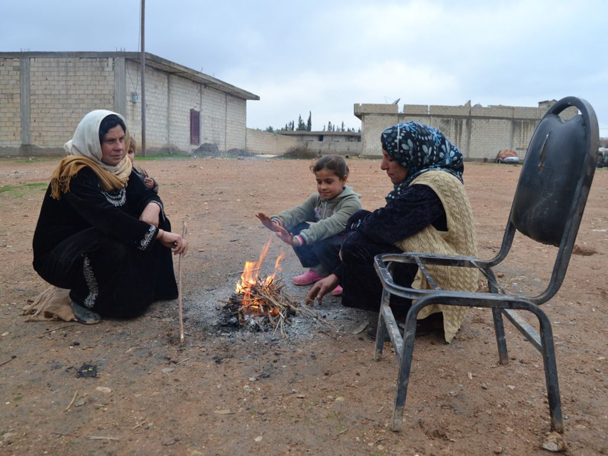 Letfiya Zelema and family huddle around a makeshift fire