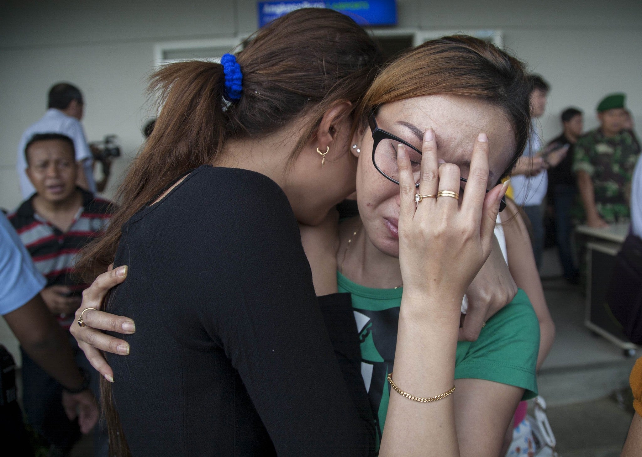 Weeping relatives await news of the Air Asia missing plane at Juanda Airport, Surabaya, Indonesia