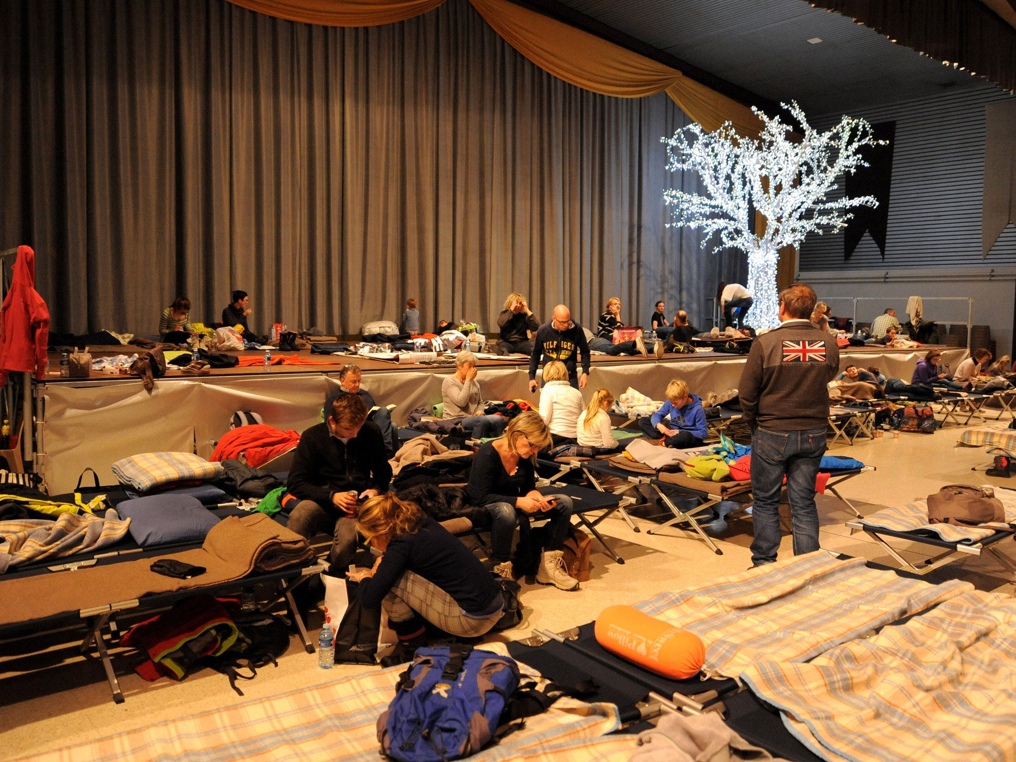 Tourists heading to ski resorts prepare to spend the night in an emergency accommodation centre after being stuck on the road due to heavy snowfalls