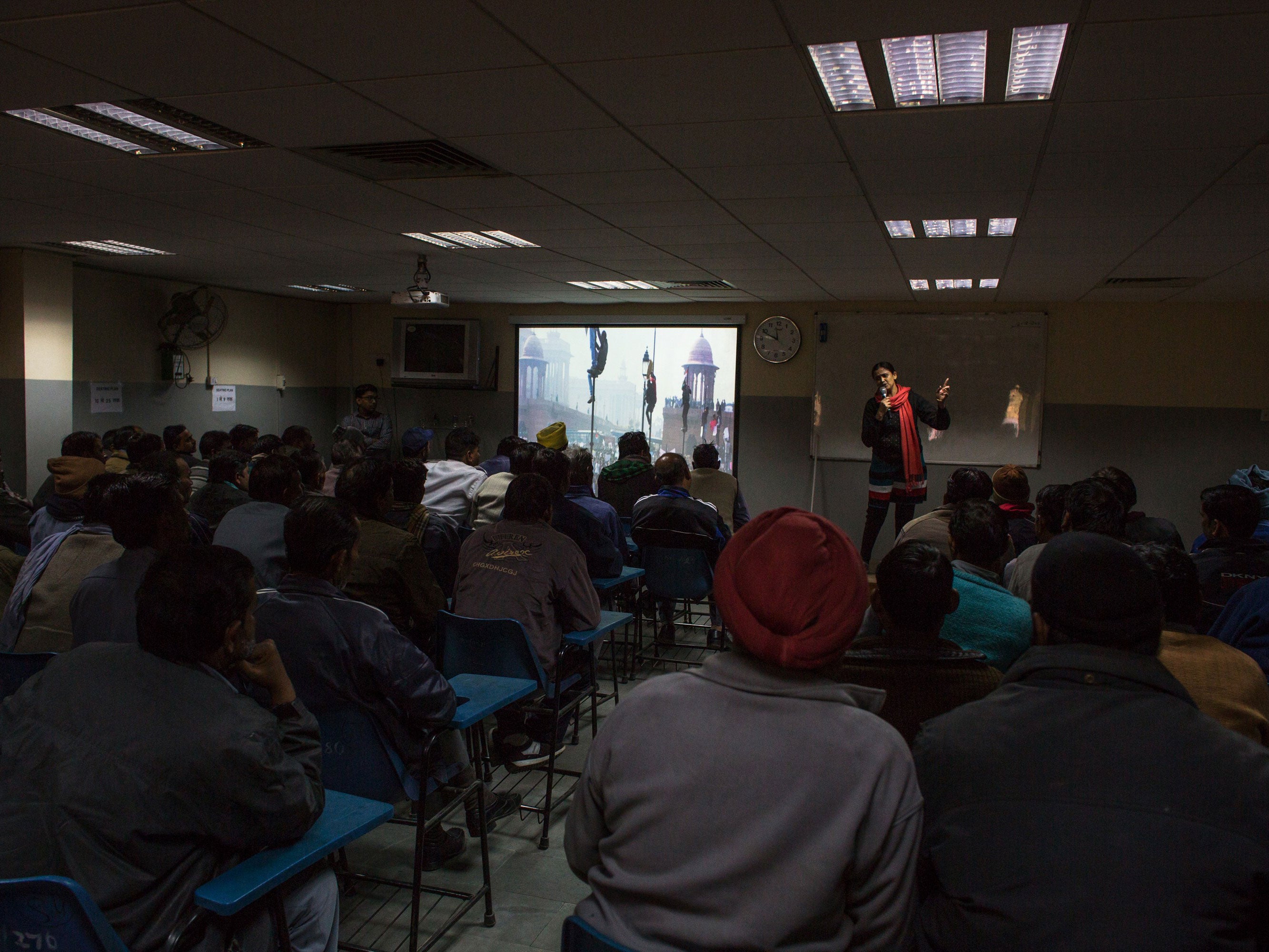 Indian auto-rickshaw drivers listen as an instructor shows an image of the protests that followed a gang rape at a gender sensitisation class