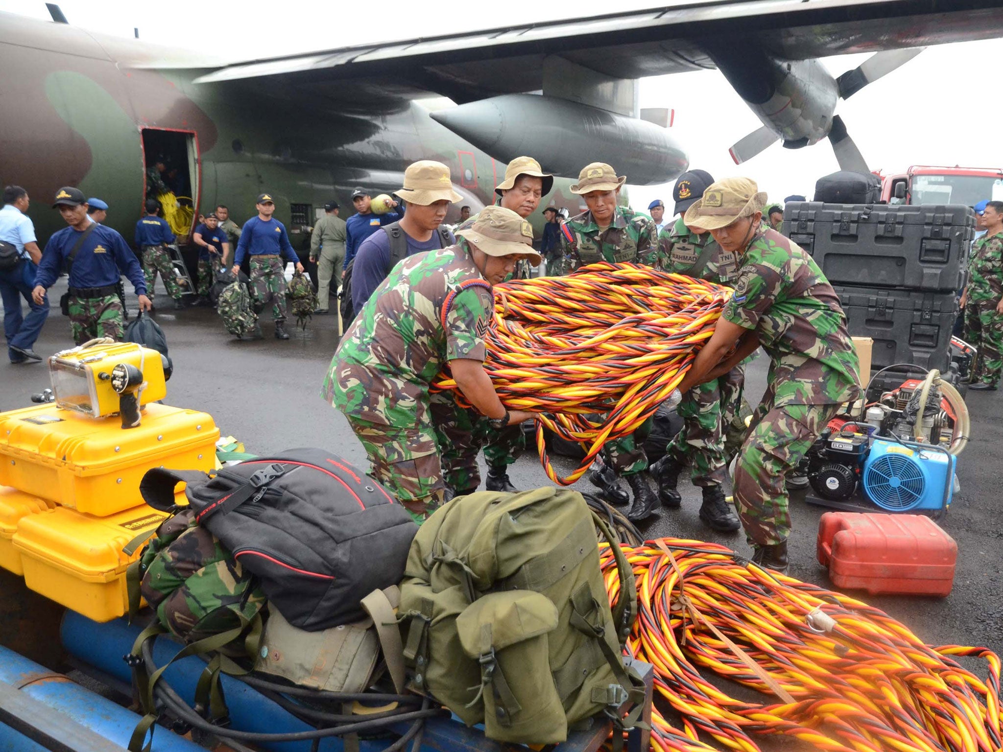 Members of the Indonesia marines unload their diving equipment as they arrive at Pangkalan Bun air base in Central Kalimantan