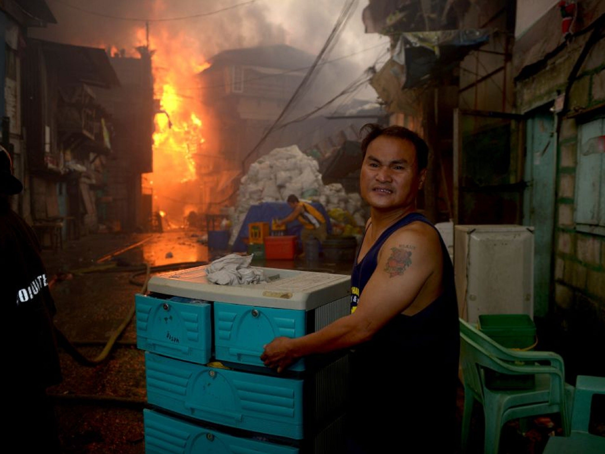 A man moves some of his belongings out of the shantytown in Manila