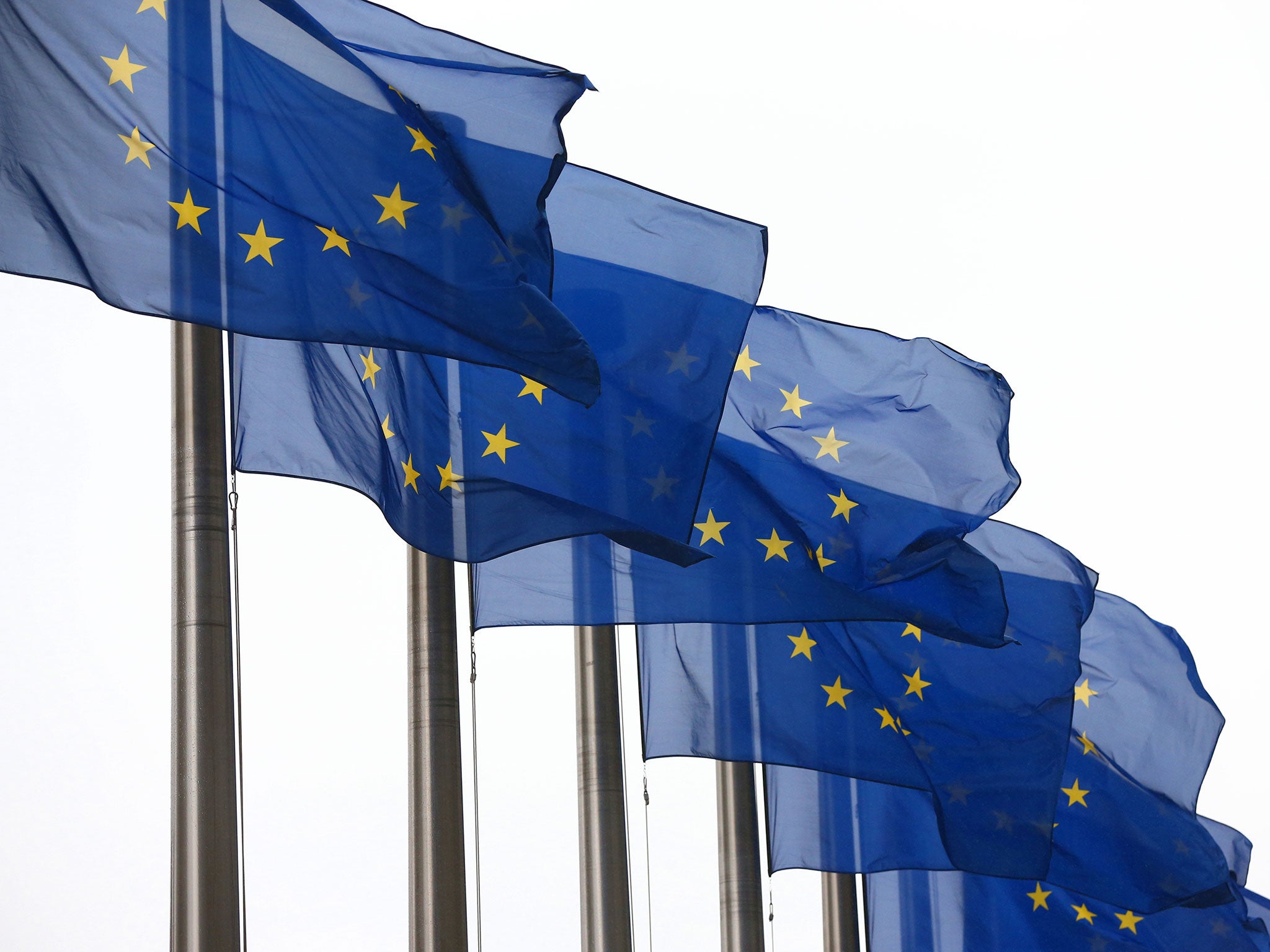 European Union flags fly outside the European Commission building in Brussels, Belgium.