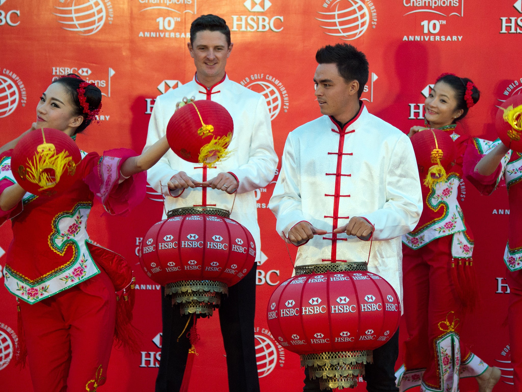 Golfers Justin Rose (2nd L) of England and Rickie Fowler of the US (C), wearing Chinese costumes, take part in a photo call for the WGC-HSBC Champions golf tournament on the historic Bund in Shanghai