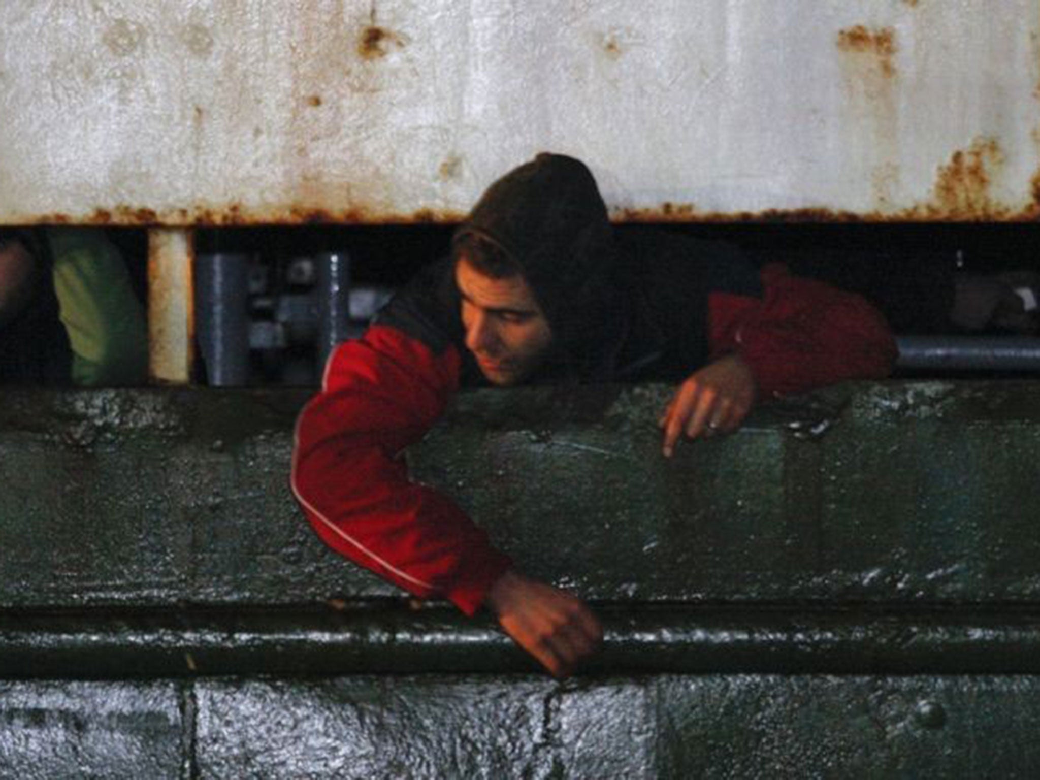 Migrants look out from the deck of the Ezadeen as they arrive at Corigliano Calabro harbour on 3 January