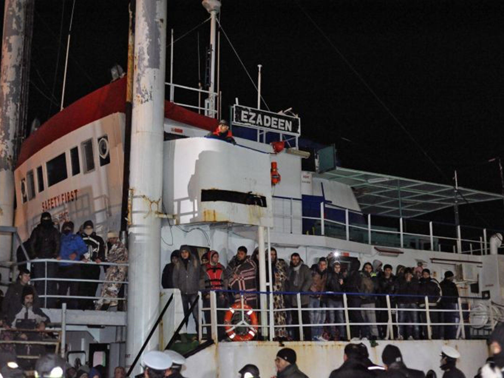 Italian police looks at migrants aboard the cargo ship 'Ezadeen' after the vessel arrived in the southern Italian port of Corigliano, Italy, 03 January