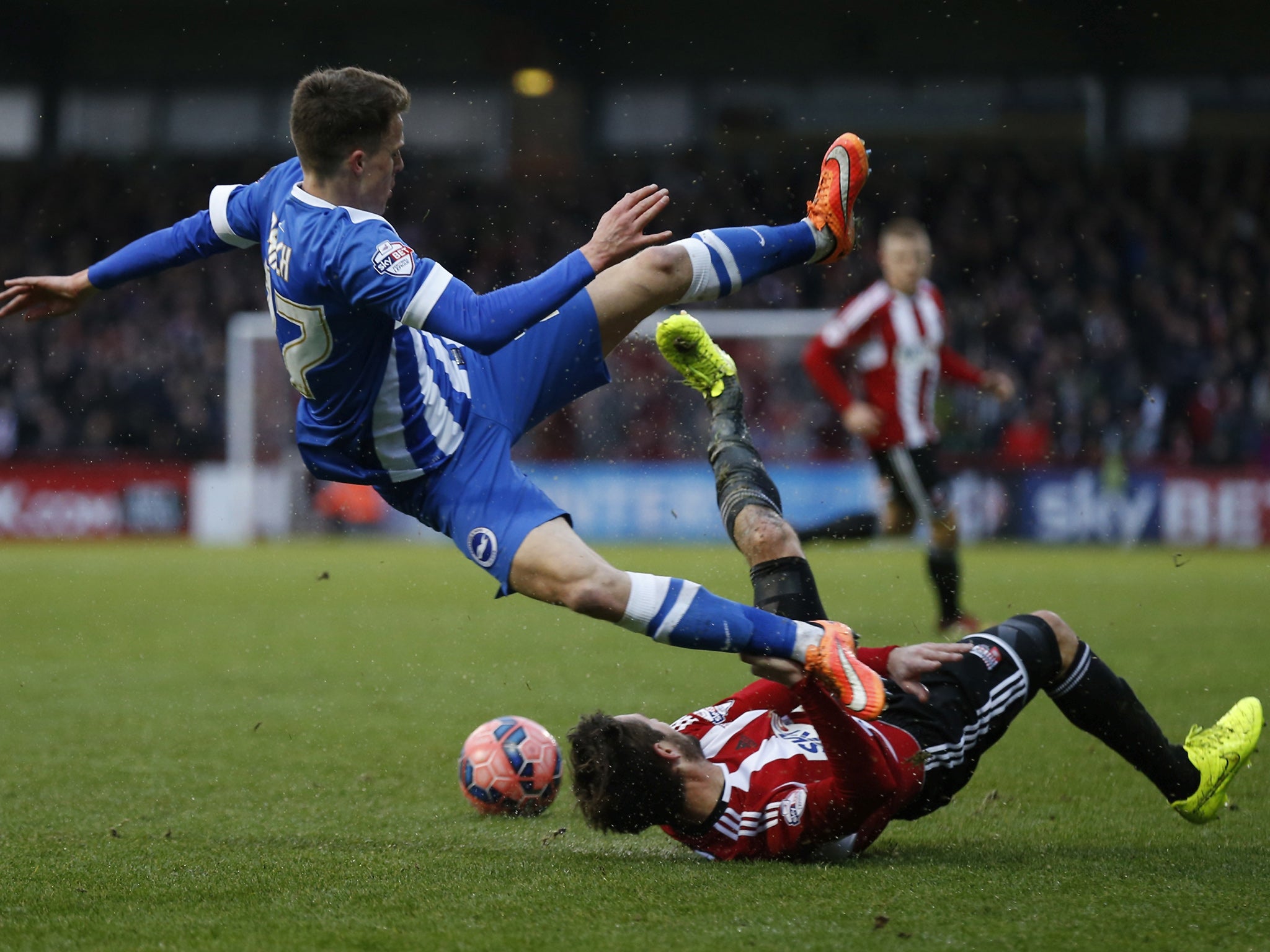 Solly March is upended by Brentford midfielder Tommy Smith