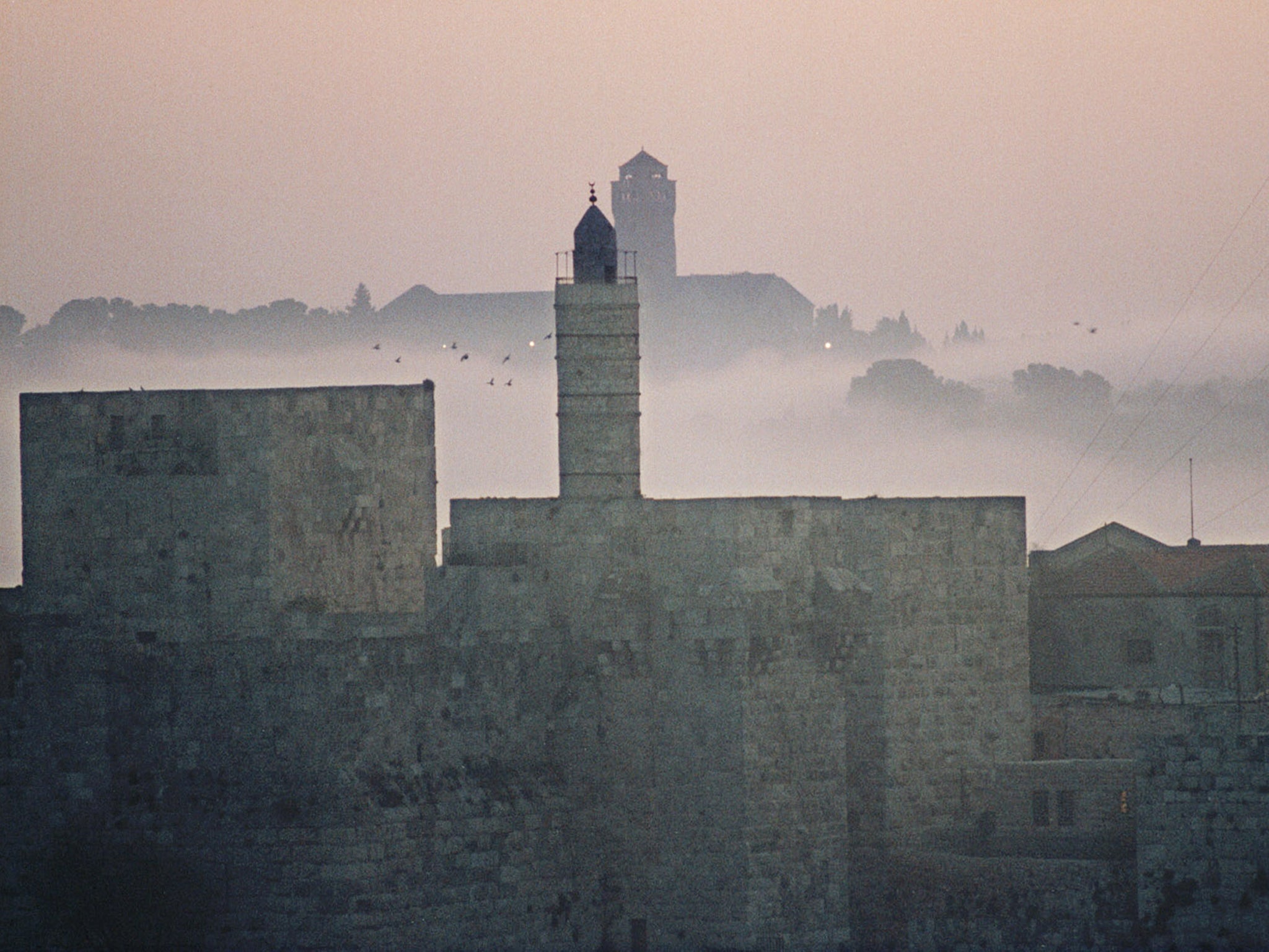 A view of the Tower of David and part of the Old City at the Jaffa Gate area of Jerusalem with mist filling the area between the Old City and Mount Scopus, behind