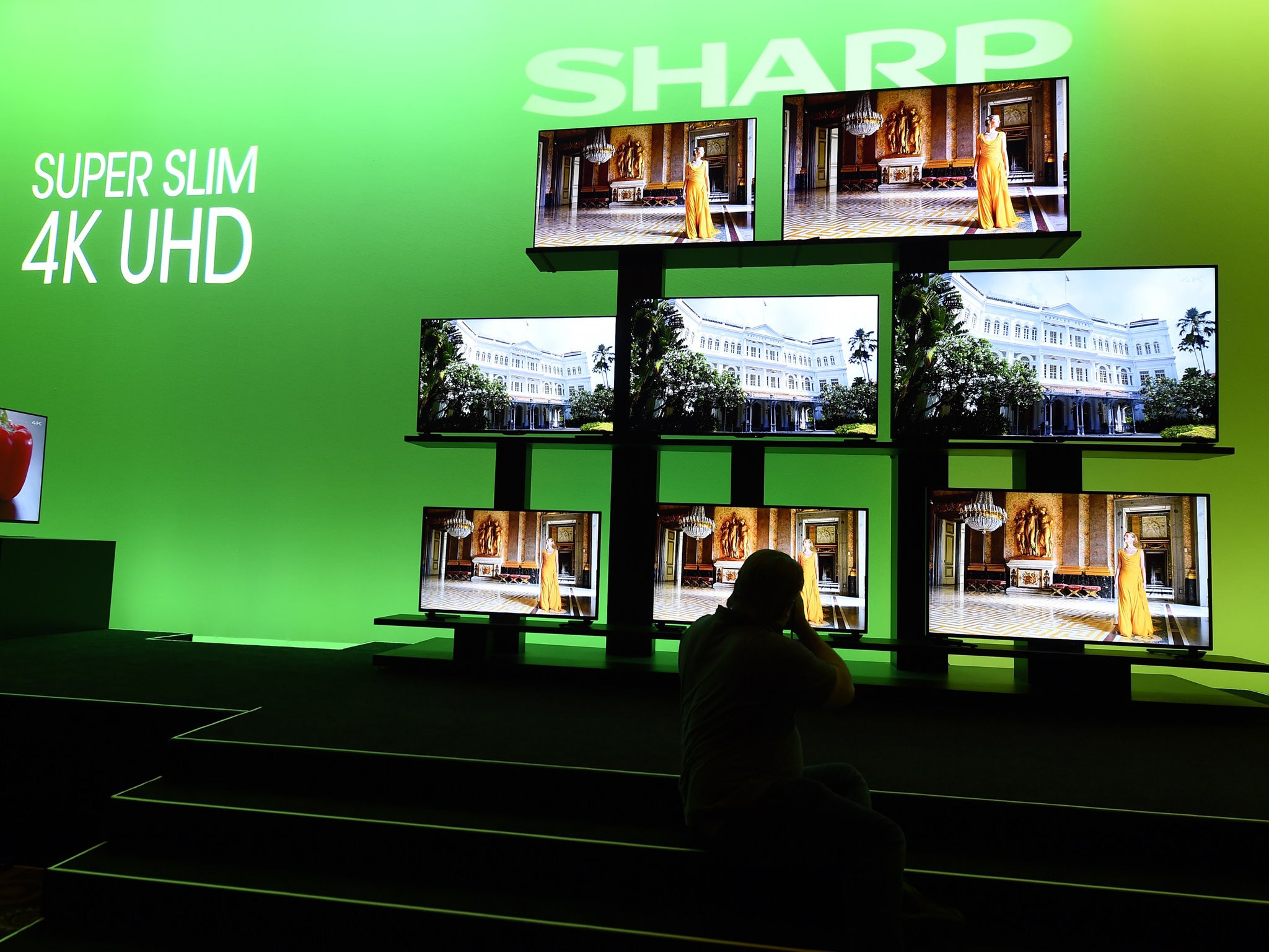 A photographer takes photos of the Sharp Super Slim 4K UHD televisions on display at the Sharp press conference at 2015 Consumer Electronics Show in Las Vegas