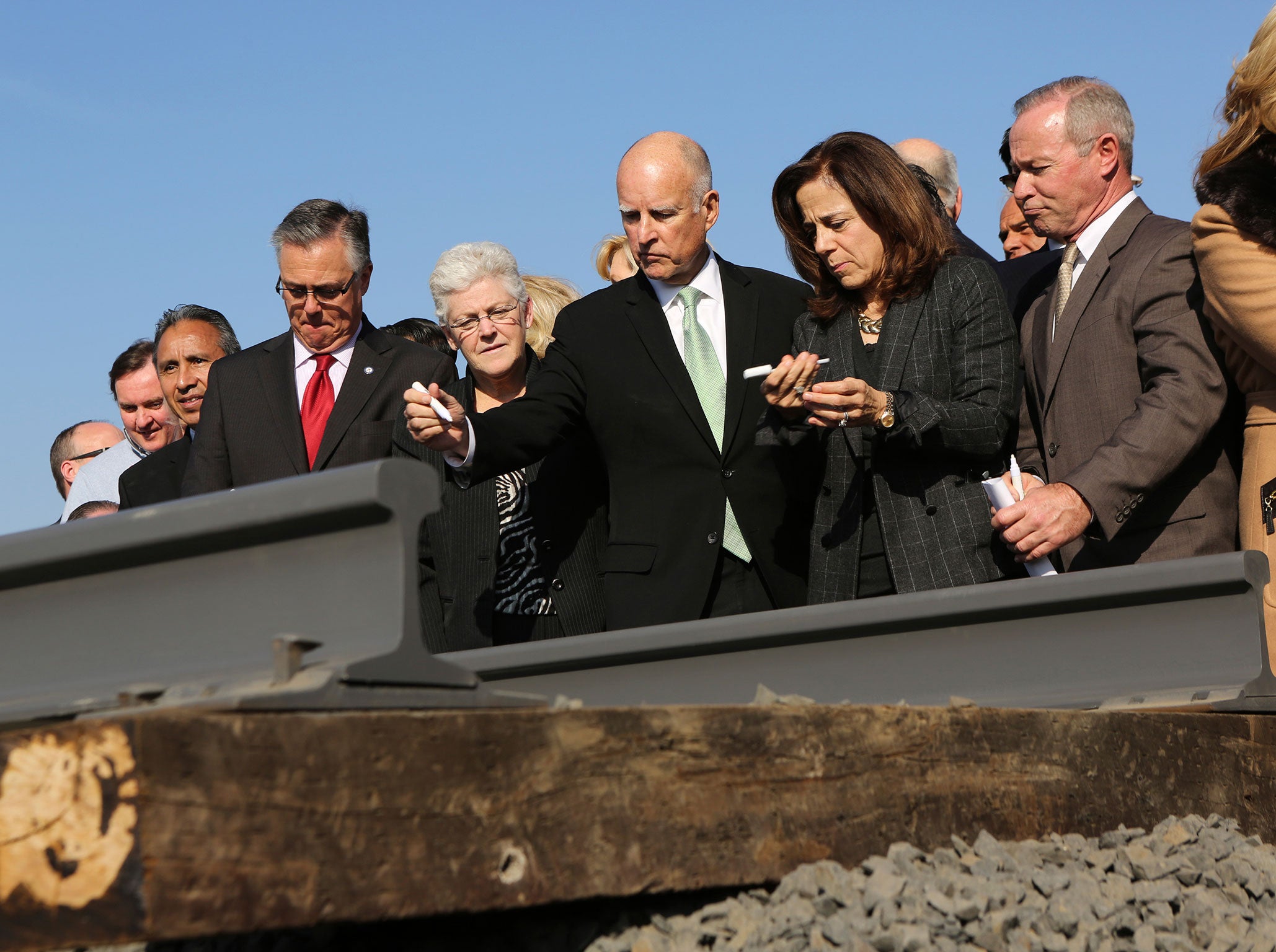 California Governor Jerry Brown and his wife, Anne Gust, prepare to sign a railroad rail during a ceremony in Fresno