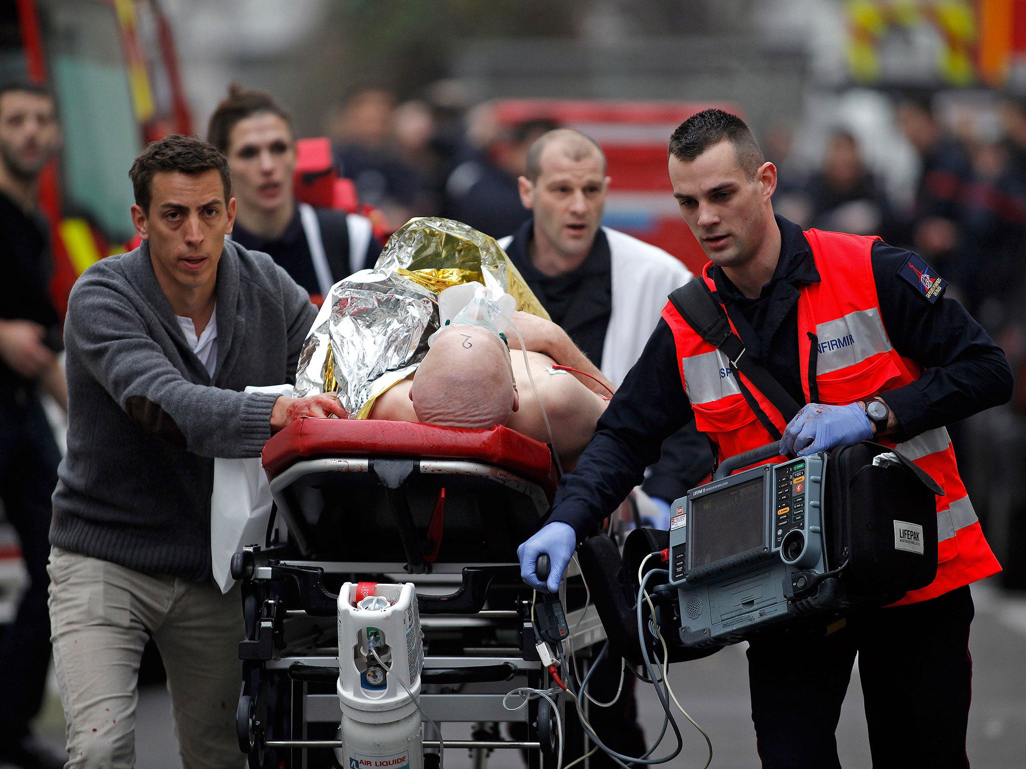 An injured person is evacuated outside the French satirical newspaper Charlie Hebdo's office in Paris