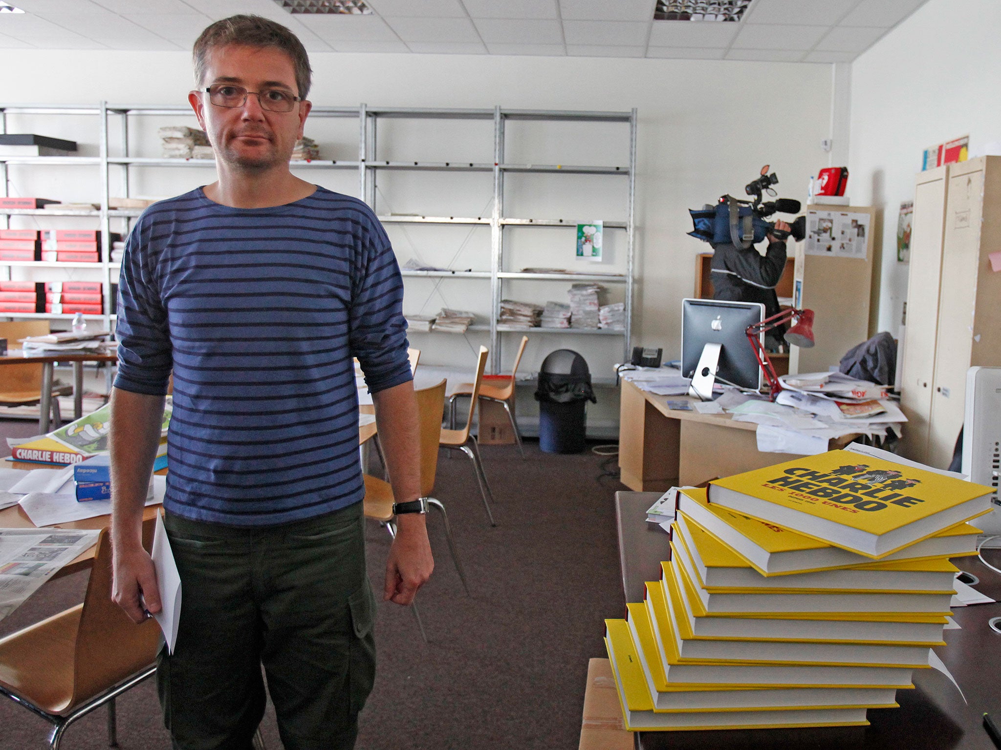 French cartoonist Charb, publishing director of French satirical weekly Charlie Hebdo, poses for photographs at their offices in Paris