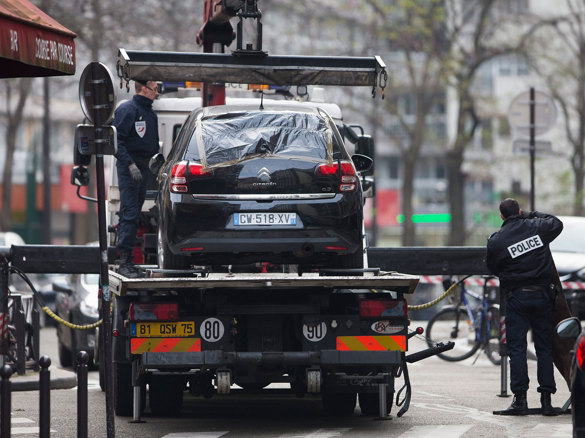 Police officers secure a vehicle allegedly used by two gunmen in an attack on the 'Charlie Hebdo' headquarters in Paris