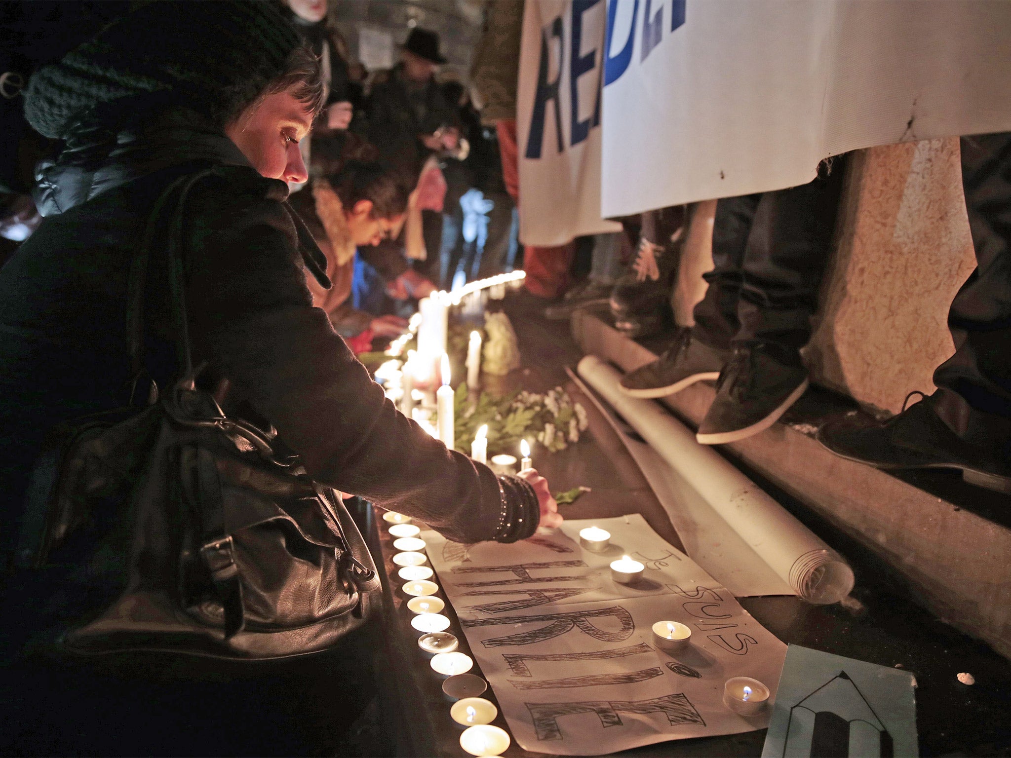 A woman lays a candle during a gathering at the Place de la Republique in Paris (Getty)