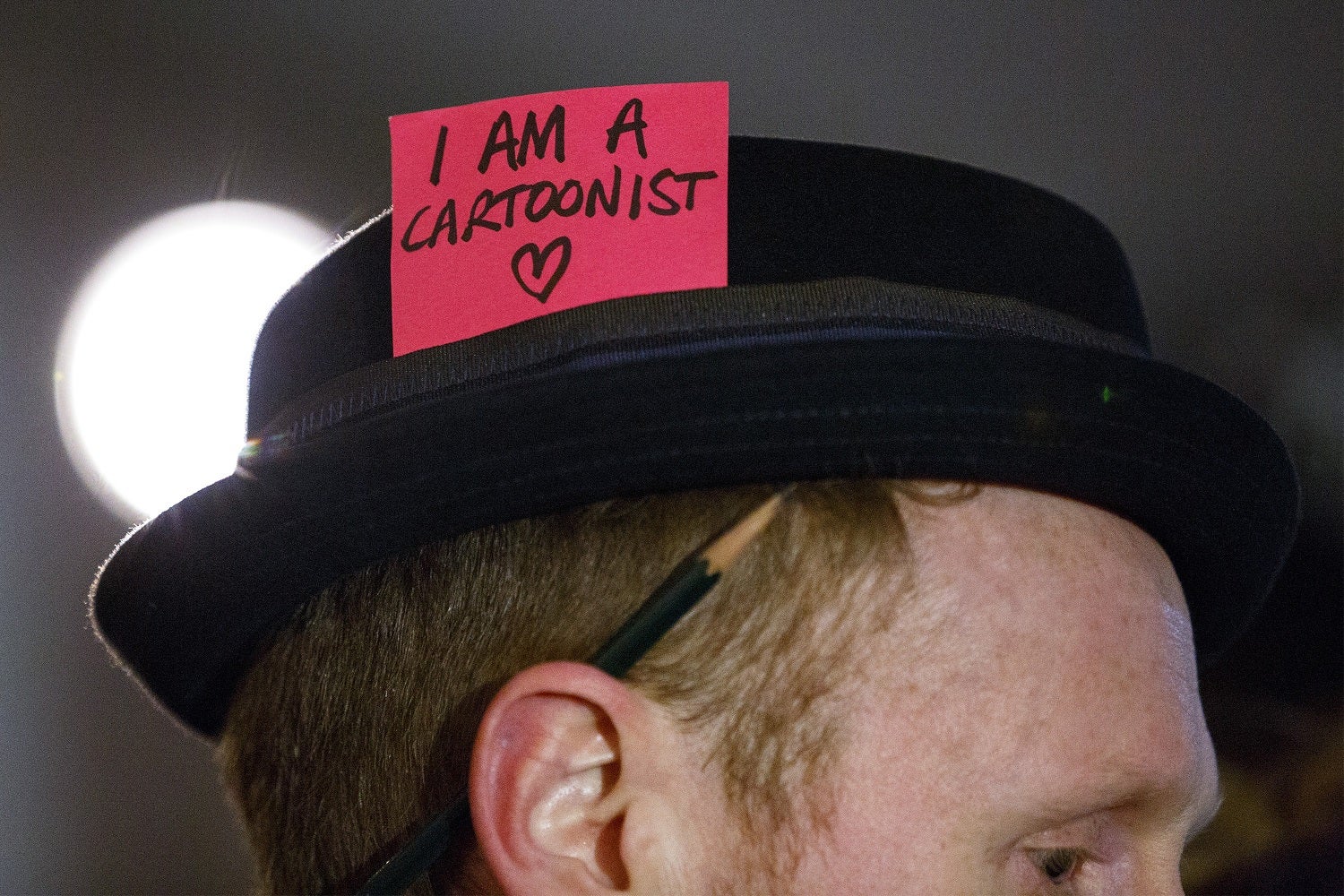 A cartoonist attends a silent vigil for the victims of the Charlie Hebdo attack in Trafalgar Square, London.