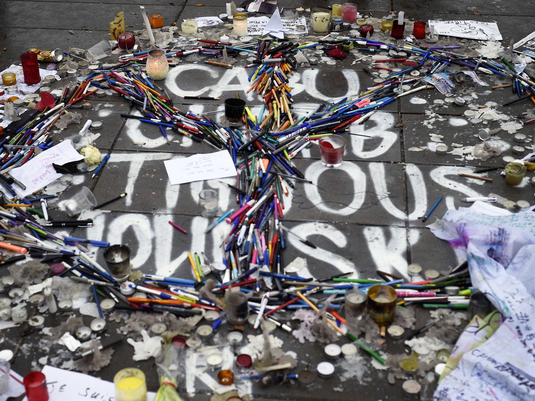 Pens and pencils are placed in the form of a peace sign over the names of late French cartoonists Cabu, Tignous, Wolinski and late Charlie Hebdo editor Charb on the Place de la Republique (Republic Square) in Paris