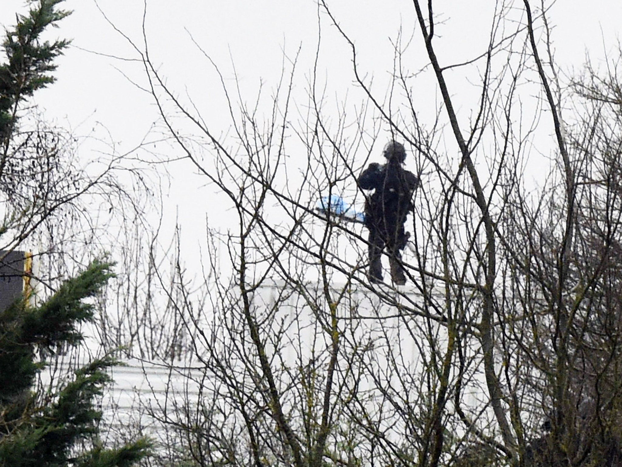 A French police officer stands on the roof of a building where two brothers suspected of slaughtering 12 people in an Islamist attack on French satirical newspaper Charlie Hebdo held one person hostage as police cornered the gunmen, in Dammartin-en-Goele