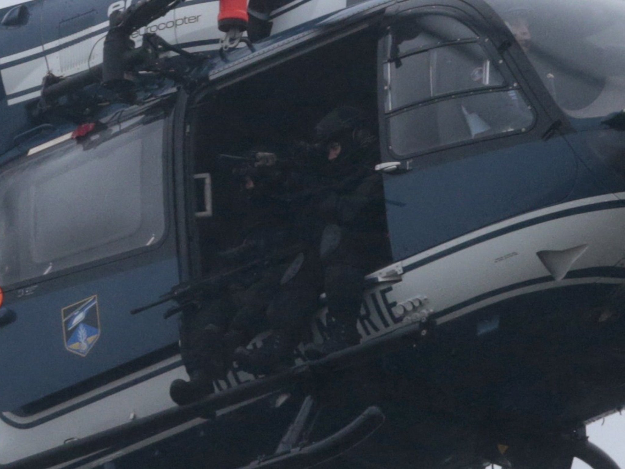 Members of the GIGN (National Gendarmerie Intervention Group) sit in a helicopter flying over Dammartin-en-Goele