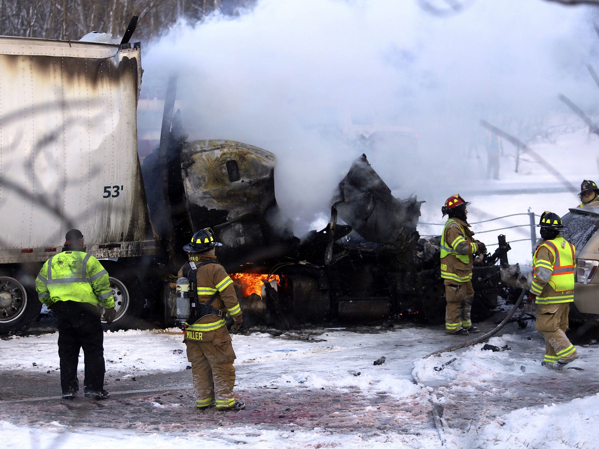 Emergency personnel work at the scene of the fiery crash