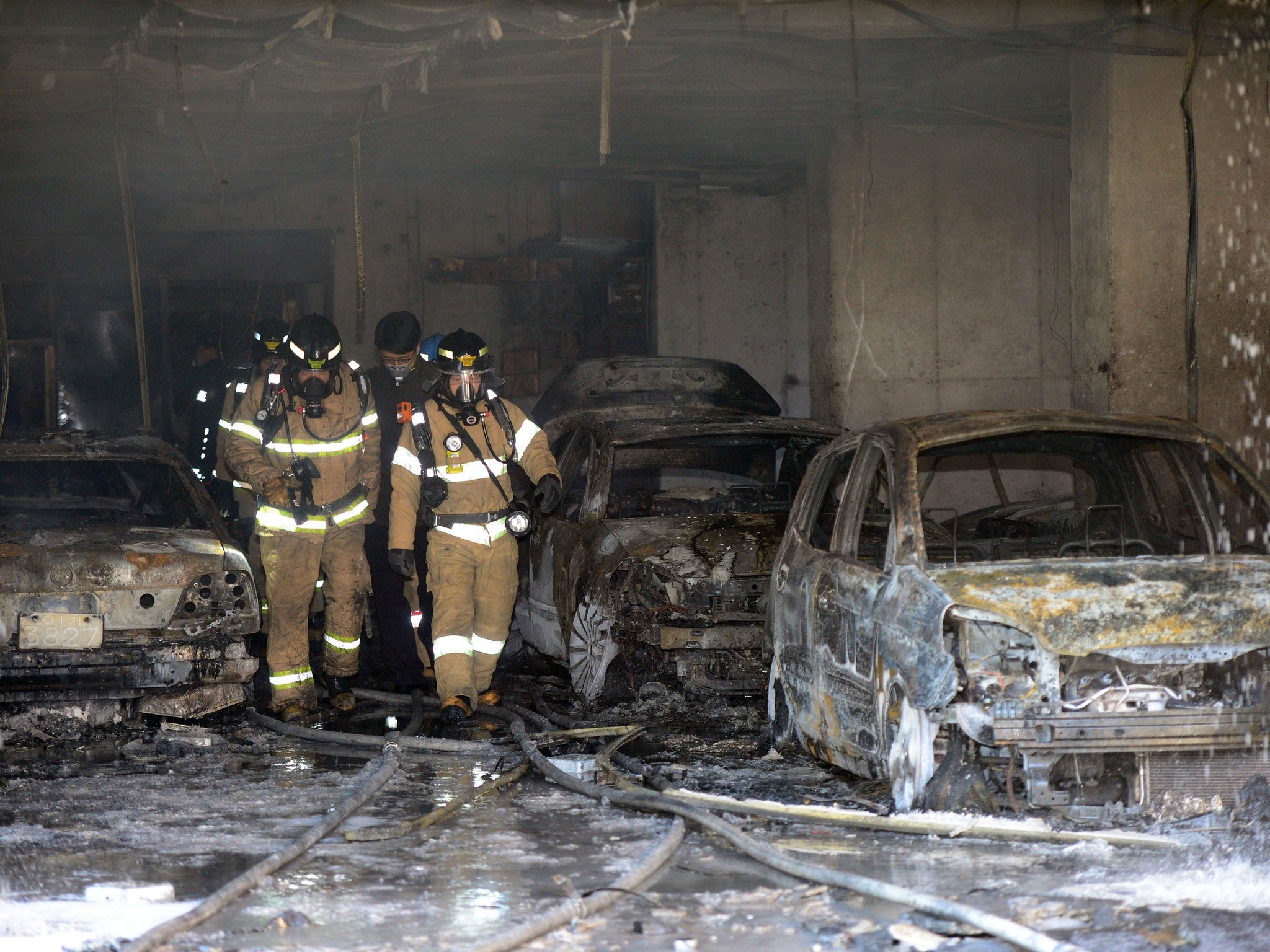 Fire fighters inspect a burnt-out apartment building in Uijeongbu (EPA)